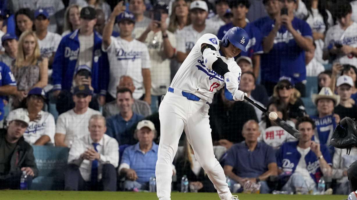 Los Angeles Dodgers' Shohei Ohtani hits RBI-single against the New York Mets during the sixth inning in Game 6 of a baseball NL Championship Series, Sunday, Oct. 20, 2024, in Los Angeles.