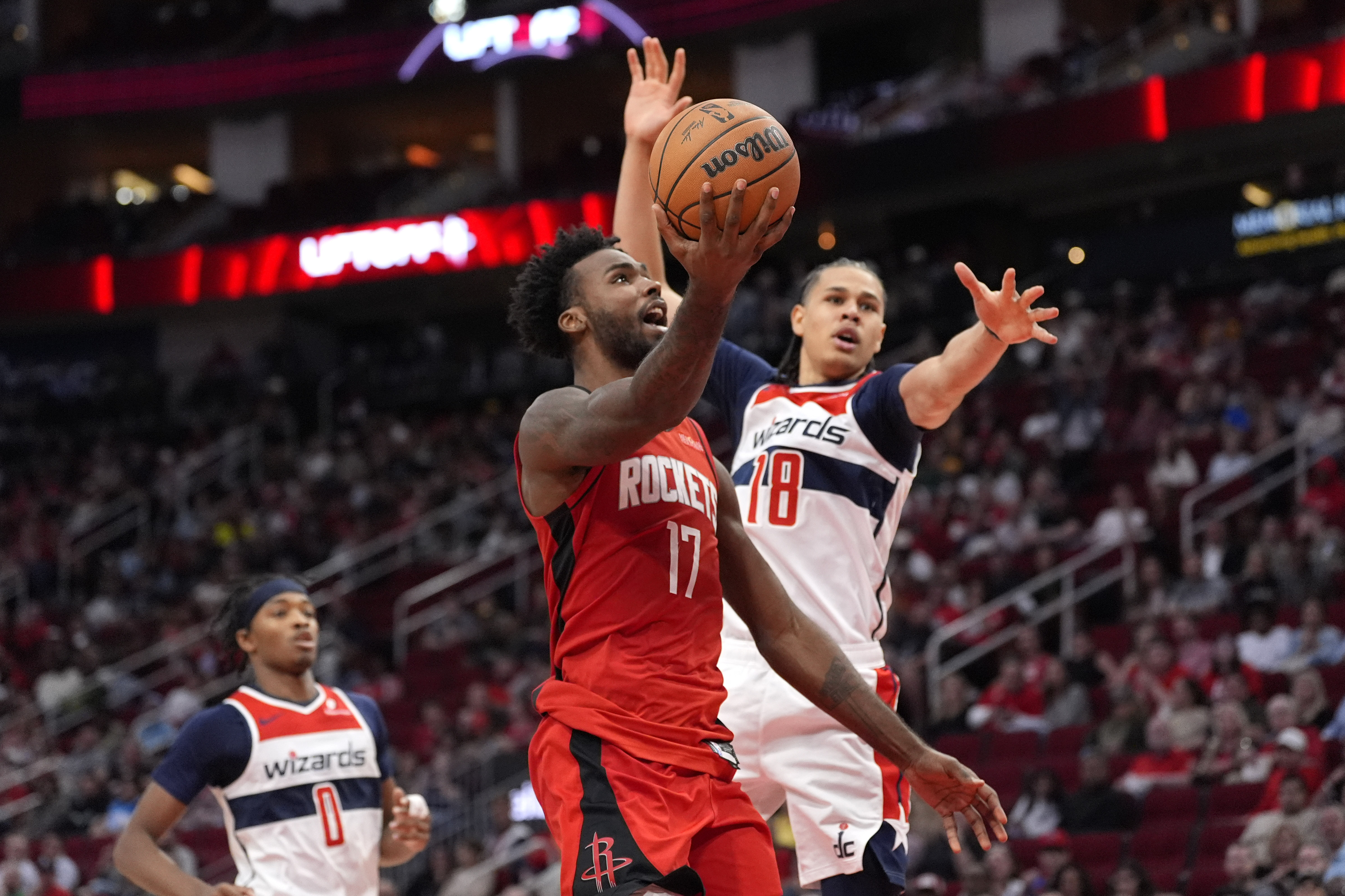Houston Rockets' Tari Eason (17) goes up for a shot as Washington Wizards' Kyshawn George (18) defends during the second half of an NBA basketball game Monday, Nov. 11, 2024, in Houston.