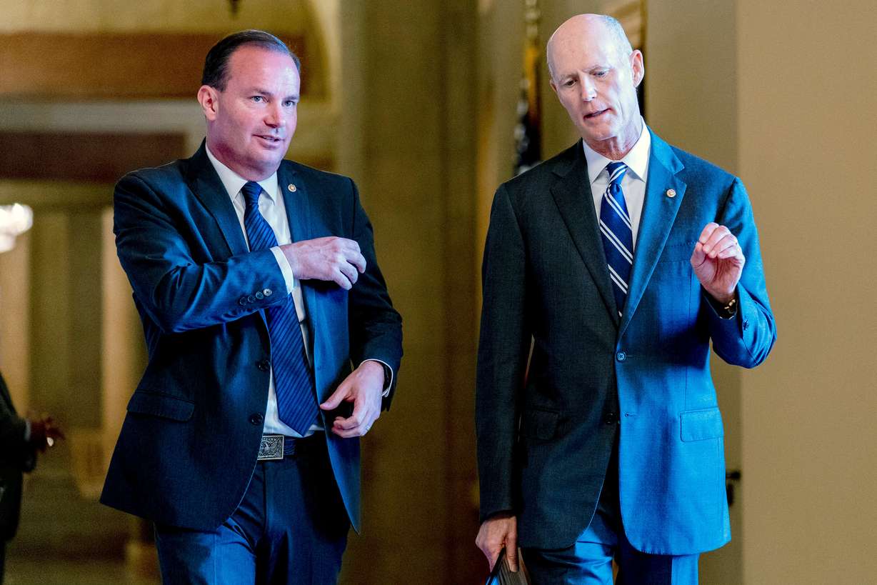 Sen. Mike Lee, R-Utah, left, and Sen. Rick Scott, R-Fla., right, walk out of a meeting in the office of Senate Minority Leader Mitch McConnell of Kentucky as the $1 trillion bipartisan infrastructure bill gets closer to passage in Washington, Aug. 9, 2021.
