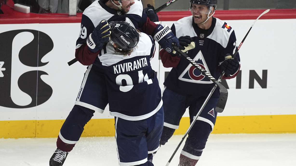 Colorado Avalanche defenseman Samuel Girard, back left, celebrates after scoring the winning goal by jumping into the arms of left wing Joel Kiviranta, front left, as right wing Logan O'Connor joins in the celebration in overtime of an NHL hockey game against the Nashville Predators, Monday, Nov. 11, 2024, in Denver.