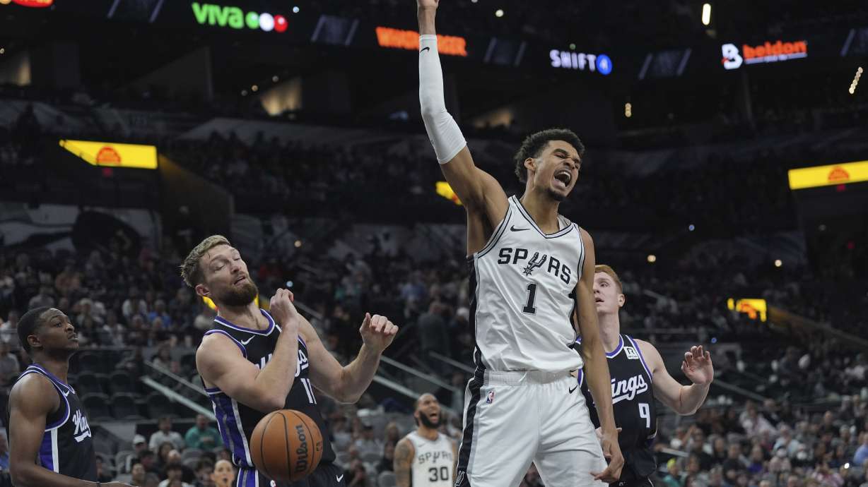 San Antonio Spurs center Victor Wembanyama (1) reacts as he scores over Sacramento Kings forward Domantas Sabonis (11) during the second half of an NBA basketball game in San Antonio, Monday, Nov. 11, 2024.
