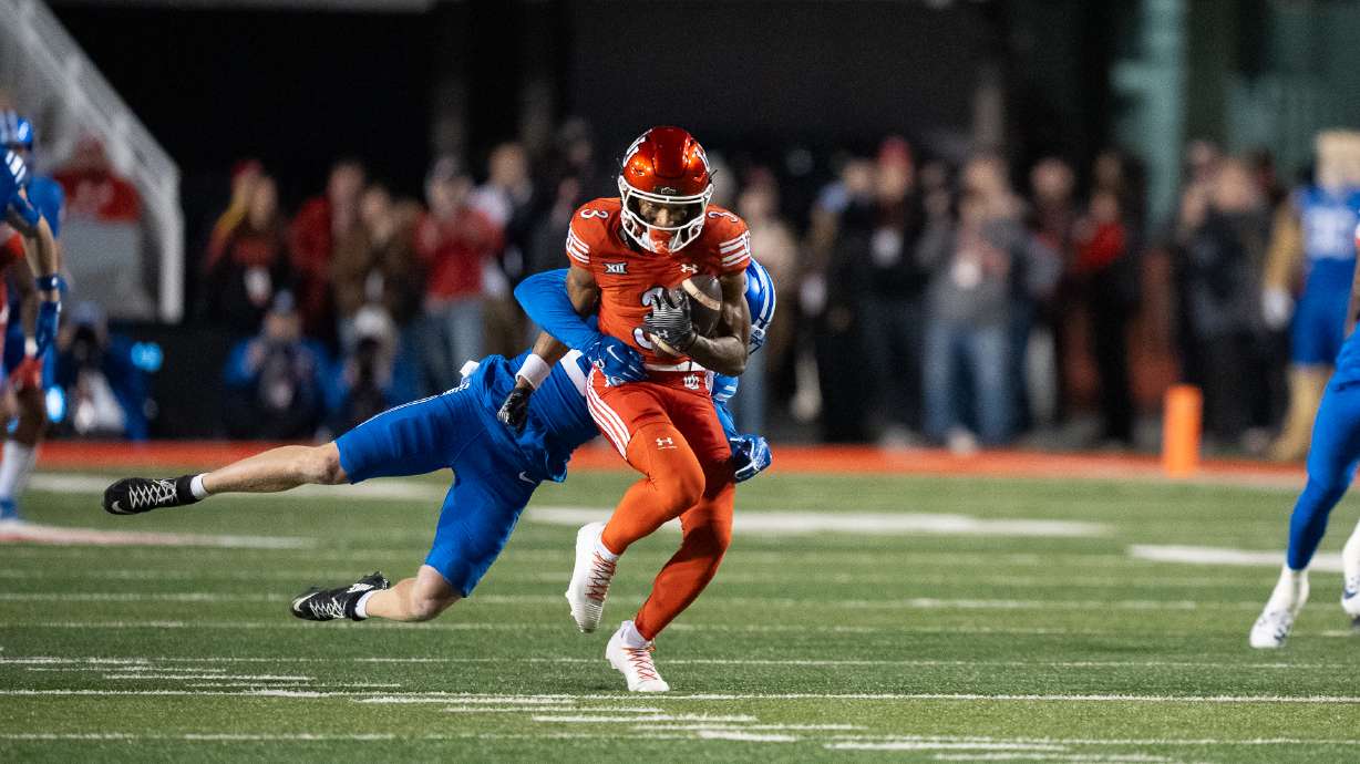 A BYU defender attempts to bring down Utah wide receiver Dorian Singer after a catch at Rice-Eccles Stadium on Nov. 9, 2024.