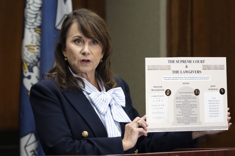 Louisiana Attorney General Liz Murrill speaks holds up a mini-display showing the Ten Commandments during a press conference regarding the Ten Commandments in schools, Aug. 5 in Baton Rouge, La.