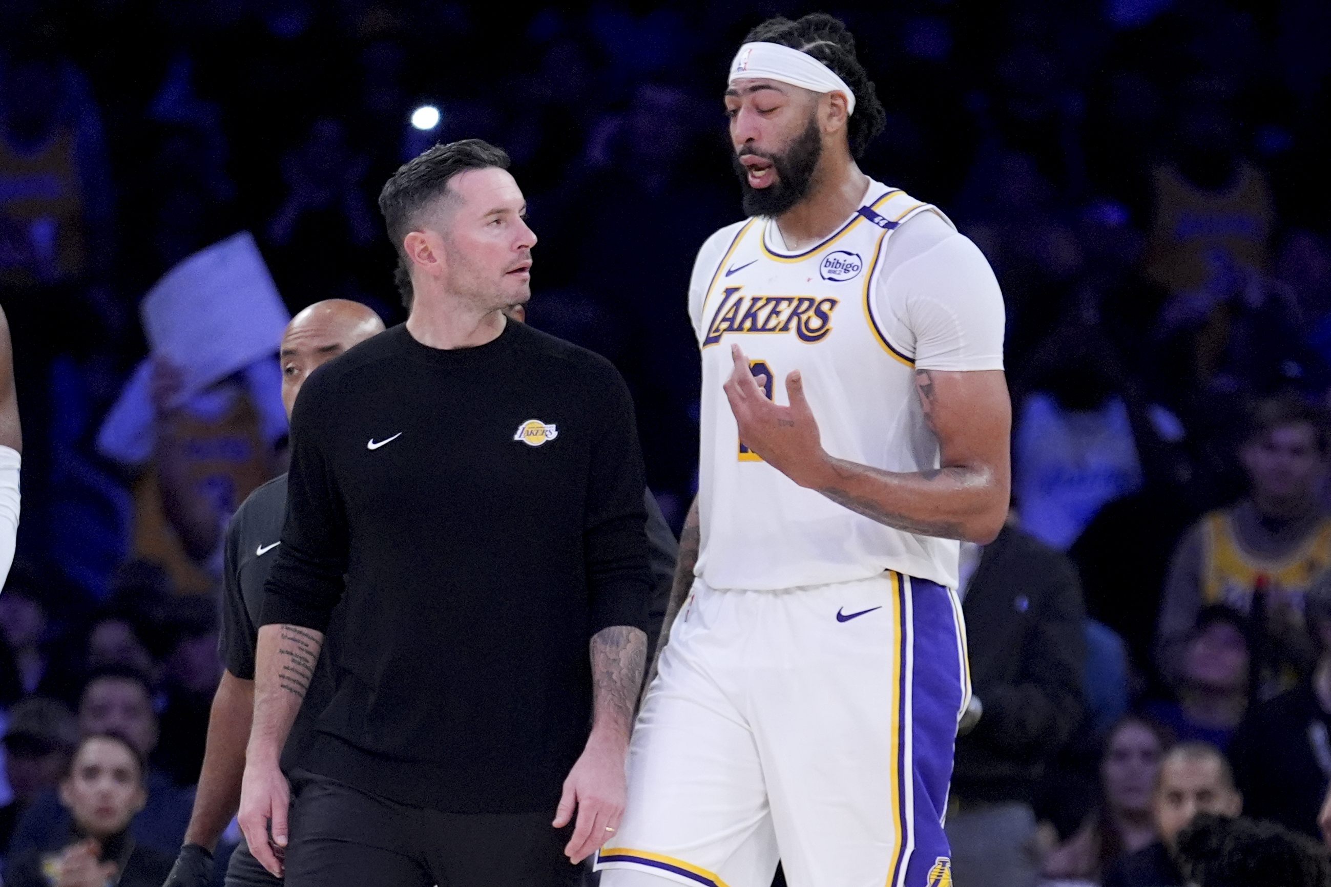 Los Angeles Lakers forward Anthony Davis, right, walks off the court with head coach JJ Redick after an injury during the second half of an NBA basketball game against the Toronto Raptors, Sunday, Nov. 10, 2024, in Los Angeles.