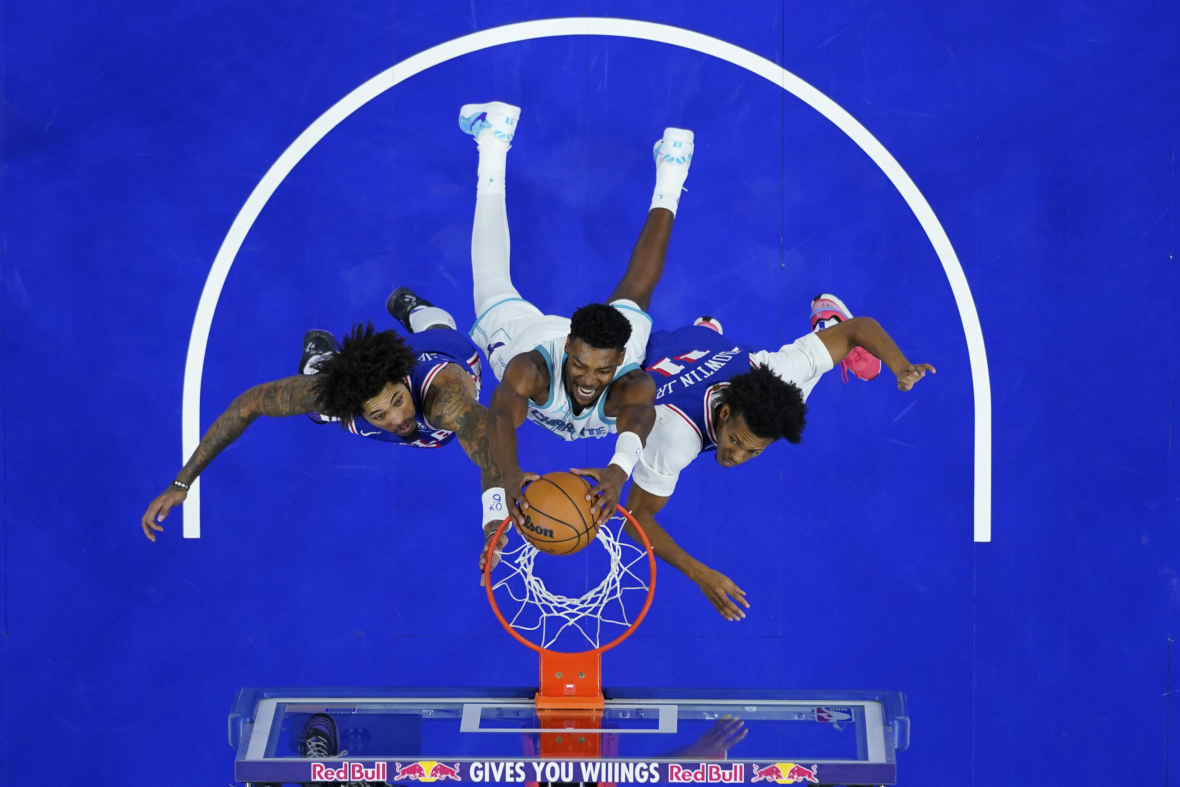 Charlotte Hornets' Brandon Miller, center, dunks between Philadelphia 76ers' Kelly Oubre Jr., left, and Jeff Dowtin Jr. during the second half of an NBA basketball game, Sunday, Nov. 10, 2024, in Philadelphia.