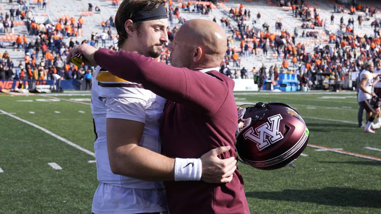 Minnesota head coach P.J. Fleck hugs quarterback Max Brosmer after the teams 25-17 win over Illinois in an NCAA college football game Saturday, Nov. 2, 2024, in Champaign, Ill.
