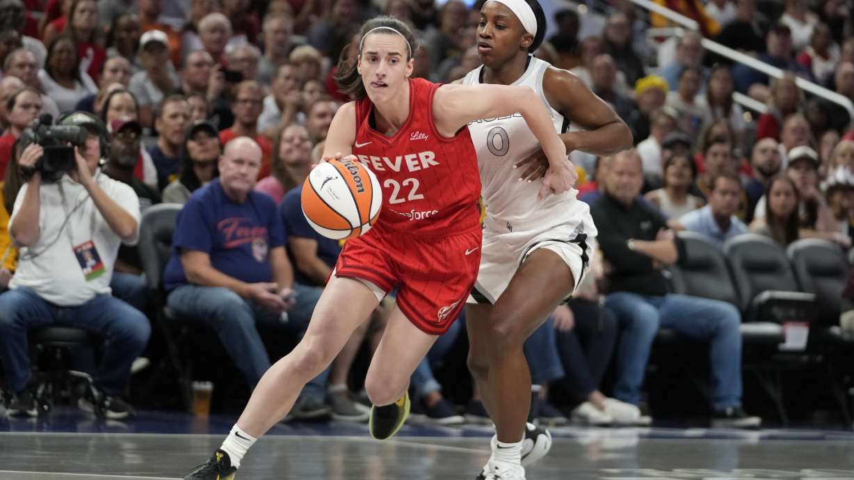FILE - Indiana Fever's Caitlin Clark (22) goes to the basket against Las Vegas Aces' Jackie Young (0) during the first half of a WNBA basketball game, Sept. 11, 2024, in Indianapolis.