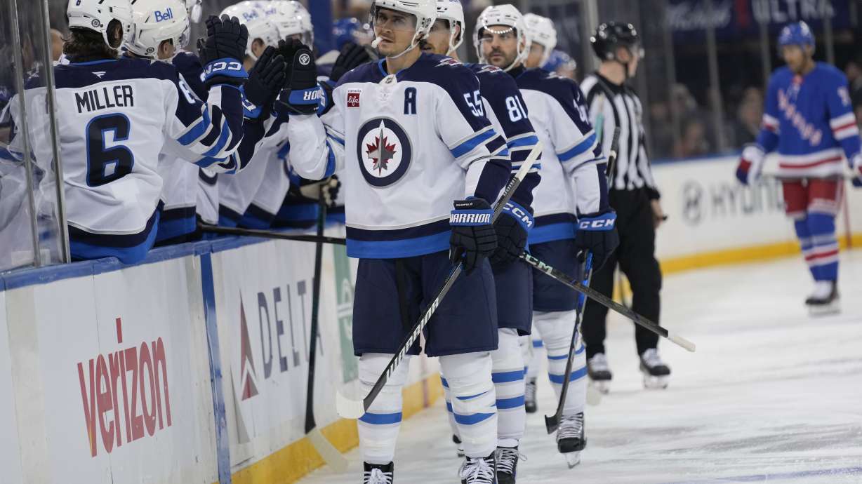 Winnipeg Jets' Mark Scheifele (55), center, celebrates with teammates after scoring during the third period of an NHL hockey game against the New York RangersTuesday, Nov. 12, 2024, in New York. The Jets defeated the Rangers 6-3.