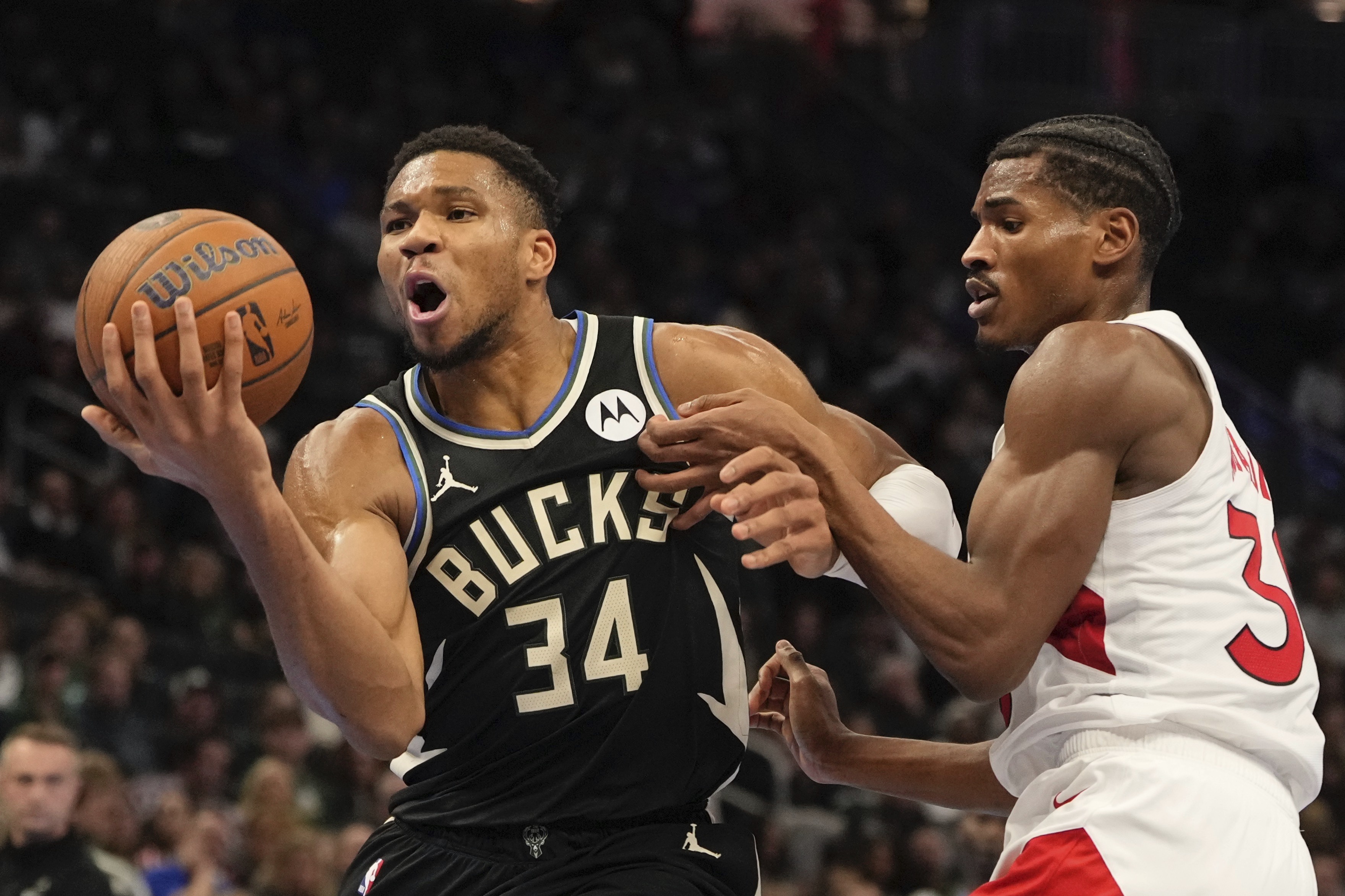 Milwaukee Bucks' Andre Jackson Jr. gets past Toronto Raptors' Ochai Agbaji during the first half of an Emirates NBA cup tournament basketball game Tuesday, Nov. 12, 2024, in Milwaukee. 