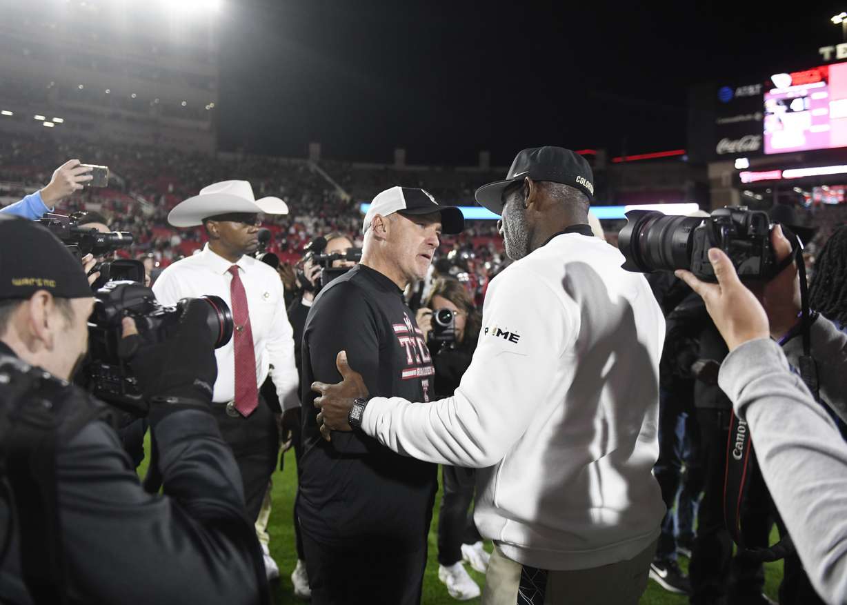 Texas Tech's head coach Joey McGuire, left, and Colorado's head coach Deion Sanders speak after the NCAA college football game, Saturday, Nov. 9, 2024, in Lubbock, Texas.