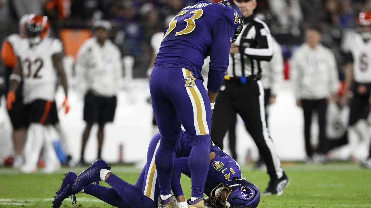 Baltimore Ravens safety Kyle Hamilton (14) is injured as linebacker Kyle Van Noy (53) stands over him during the first half of an NFL football game against the Cincinnati Bengals, Thursday, Nov. 7, 2024, in Baltimore.