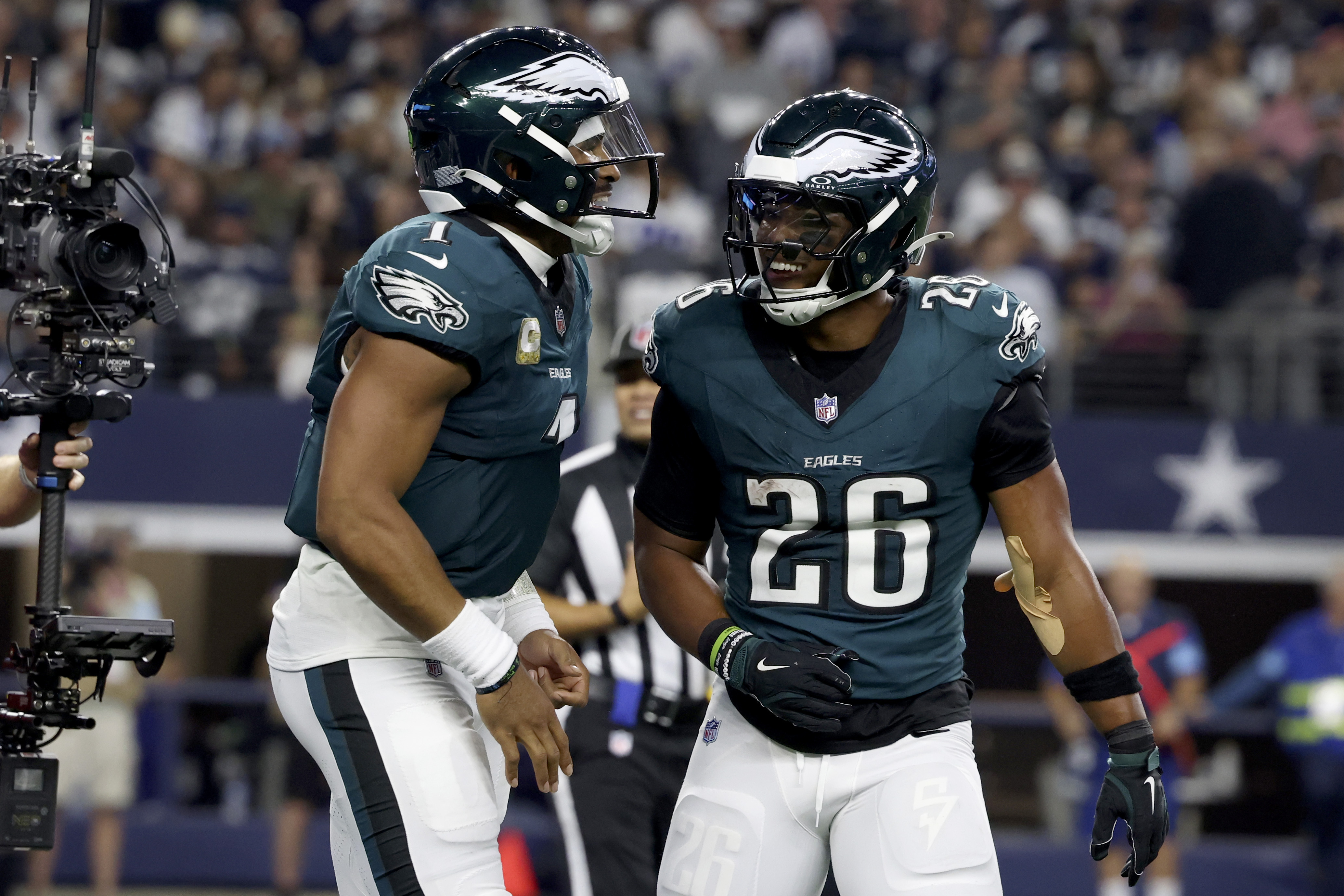 Philadelphia Eagles' Jalen Hurts, left, and Saquon Barkley (26) celebrate after Hurts ran the ball for a touchdown in the second half of an NFL football game in Arlington, Texas, Sunday, Nov. 10, 2024.