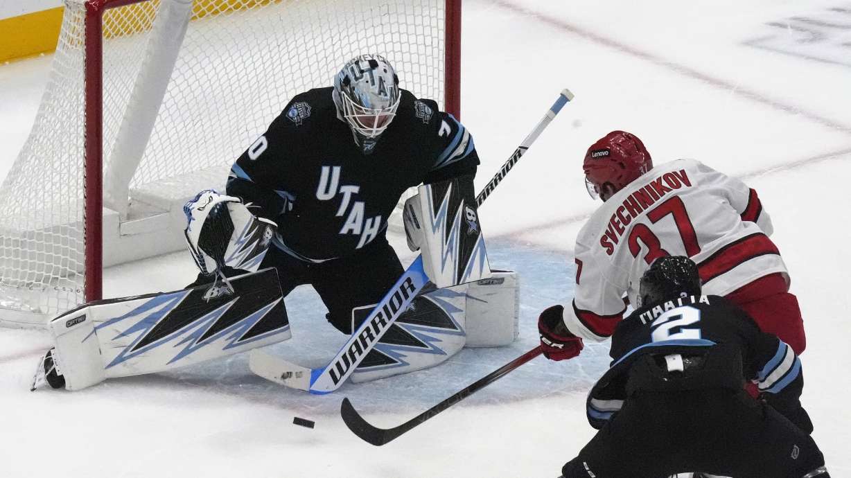 Utah Hockey Club goaltender Karel Vejmelka (70) makes a save against Carolina Hurricanes right wing Andrei Svechnikov (37) during the first period of an NHL hockey game Wednesday, Nov. 13, 2024, in Salt Lake City.