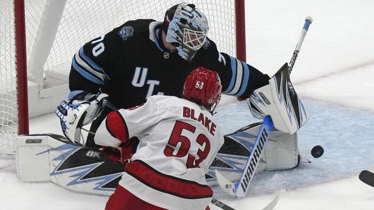 Utah Hockey Club goaltender Karel Vejmelka (70) makes a save against Carolina Hurricanes right wing Jackson Blake (53) during the third period of an NHL hockey game Wednesday, Nov. 13, 2024, in Salt Lake City.