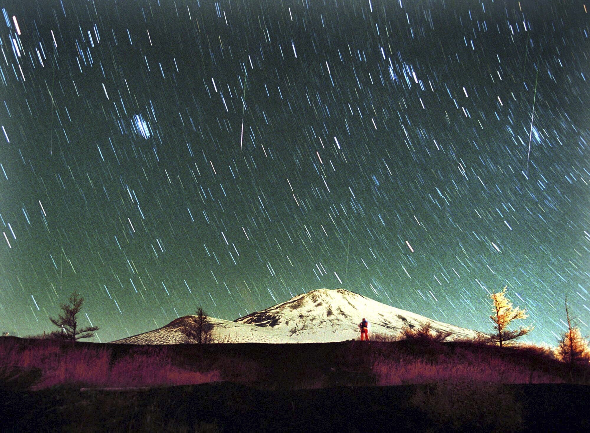 Leonid meteors are seen streaking across the sky over snow-capped Mount Fuji, Japan's highest mountain, in this seven-minute exposure photo taken, Nov. 19, 2001. A supermoon will obscure much of an upcoming Leonid meteor shower.