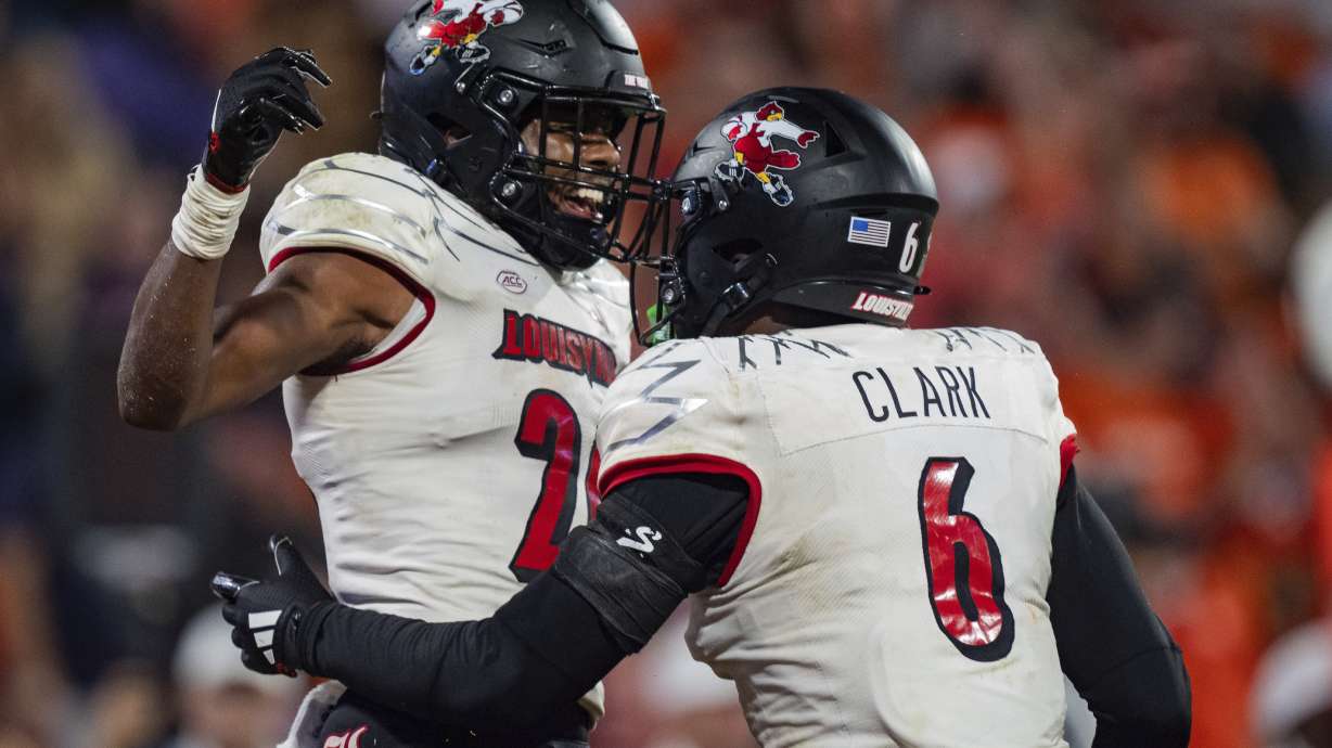 Louisville defensive back M.J. Griffin (26) celebrates with linebacker Stanquan Clark (6) in the second half of an NCAA college football game against Clemson, Saturday, Nov. 2, 2024, in Clemson, S.C.