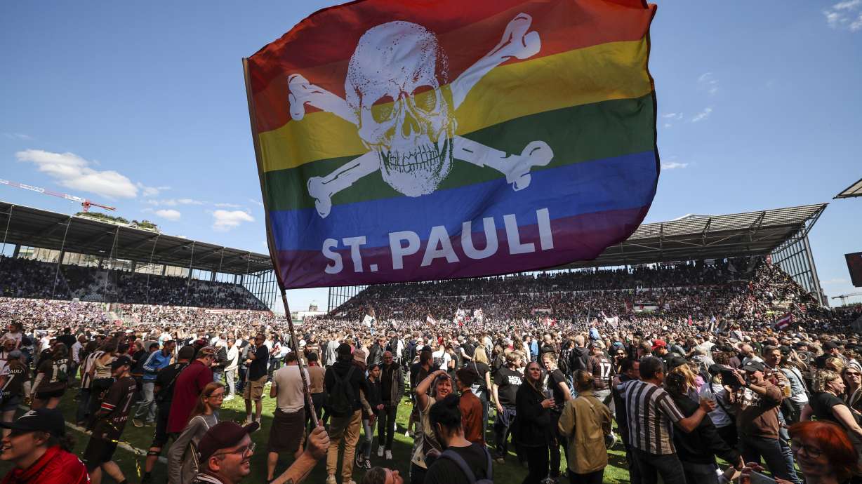 FILE - St. Pauli's fans invade the field after their team won 3-1 during a second division, Bundesliga soccer match at the Millerntor Stadium, in Hamburg, Germany, May 12, 2024.