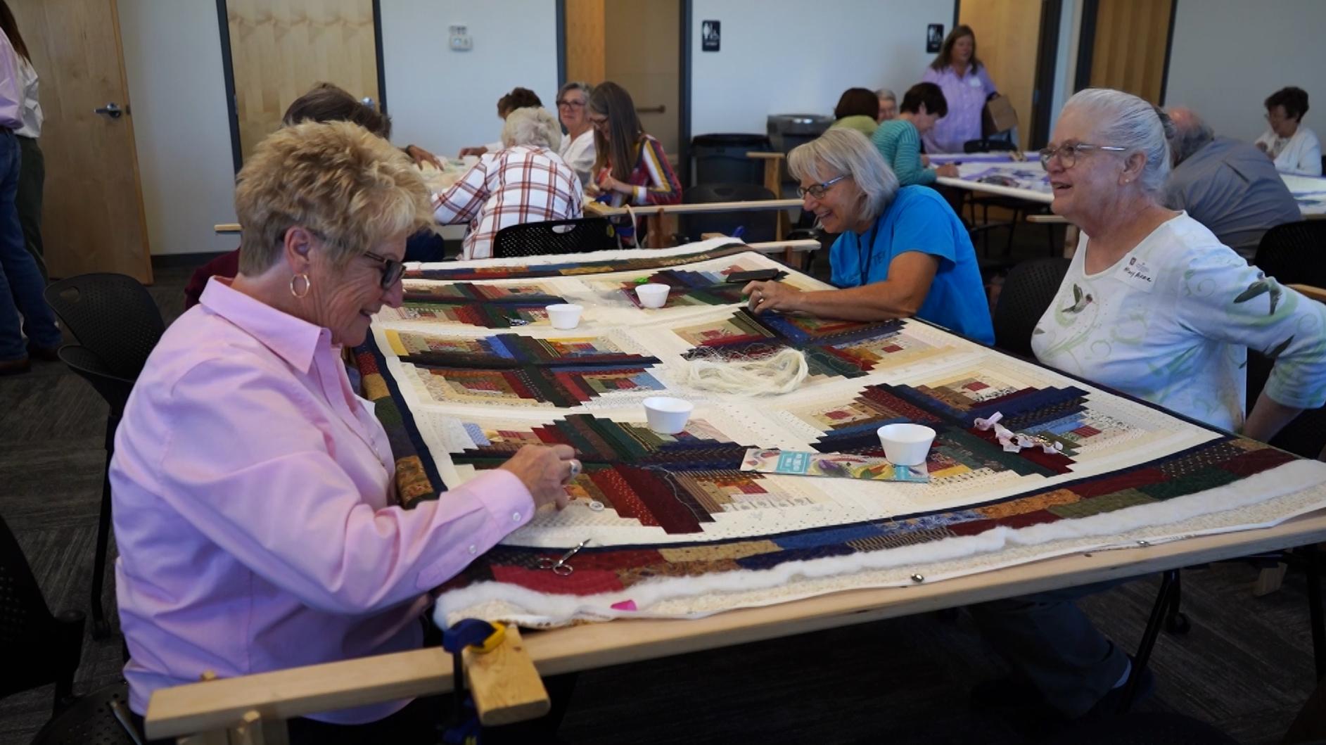 Women work on a quilt for this weekend's quilt show that displays only hand-quilted quilts. It is hosted by Intermountain Foundation and raises funds for Primary Children's Hospital's fetal center.