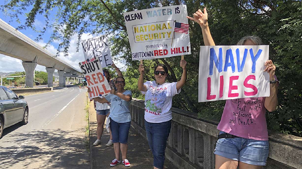 People protest the Department of Defense's response to the leak of jet fuel into the water supply protest at Joint Base Pearl Harbor-Hickam, Hawaii, Sept. 30, 2022. A watchdog says Navy officials lacked sufficient understanding of fuel storage risks.