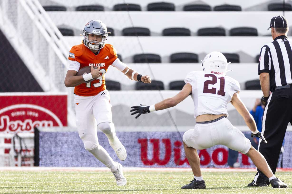 Skyridge quarterback Kaneal Sweetwyne (13) runs the ball while guarded by Lone Peak cornerback Toa Tanuvasa (21) during a 6A high school football semifinal game held at Rice-Eccles Stadium in Salt Lake City on Thursday, Nov. 14, 2024.