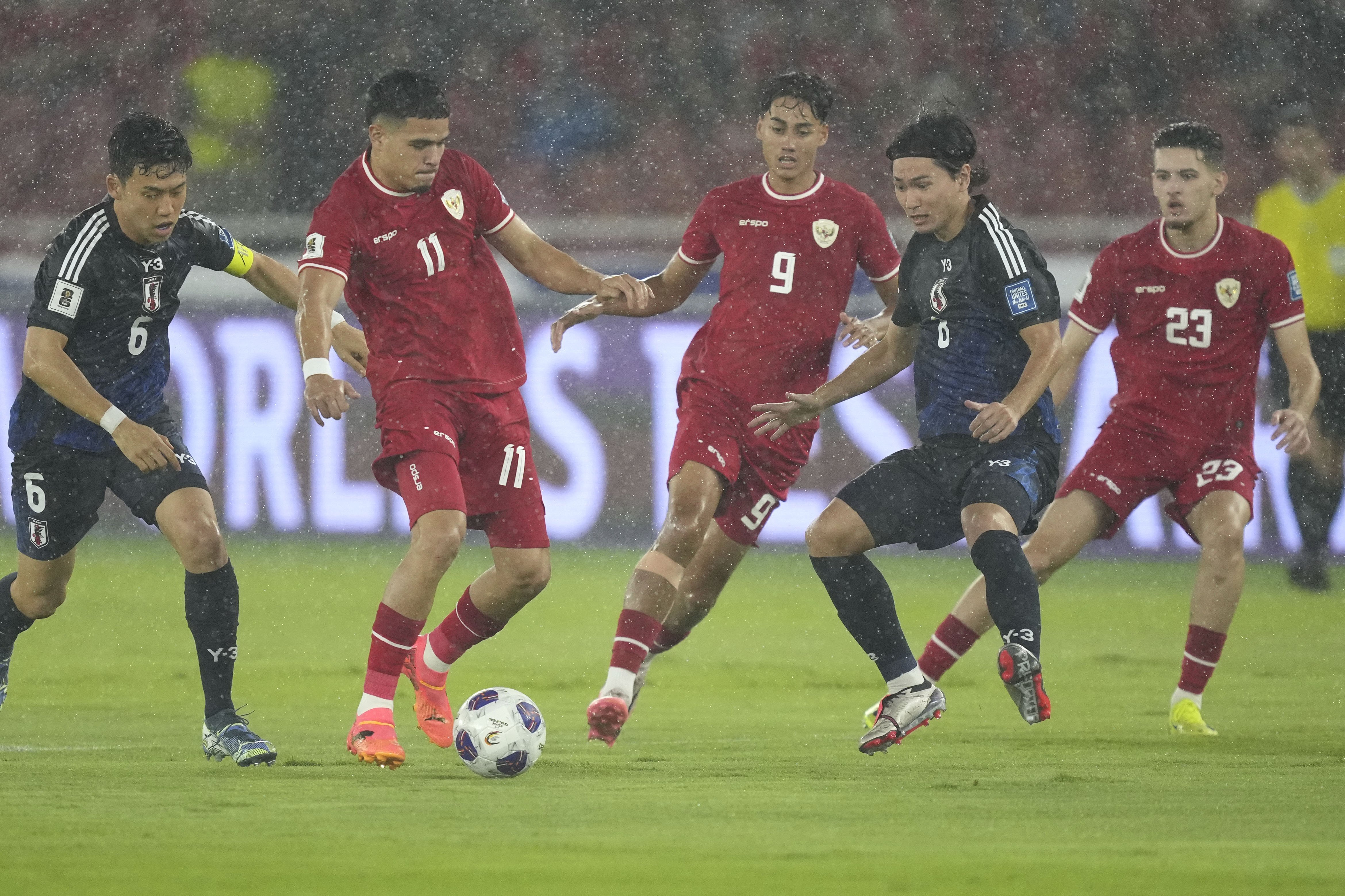 Japan's Wataru Endo, left, and Takumi Minamino, second right, battle for the ball against Indonesia's Ragnar Oratmangoen, second left, Rafael Struick, center, and Justin Hubner, right, during their 2026 World Cup Asian 3rd round qualifier soccer match at Gelora Bung Karno Main Stadium in Jakarta, Indonesia, Friday, Nov. 15, 2024.