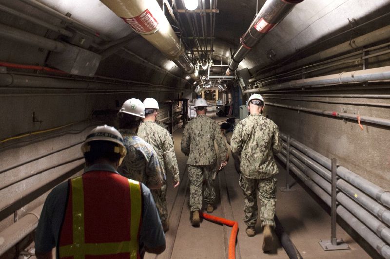 Rear Adm. John Korka, leads Navy and civilian water quality recovery experts through the tunnels of the Red Hill Bulk Fuel Storage Facility, near Pearl Harbor, Hawaii, on Dec. 23, 2021.