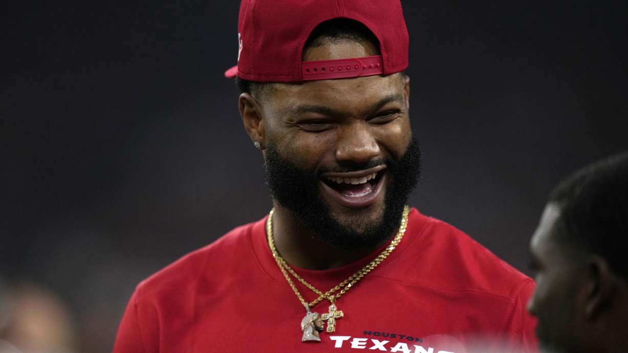 Injured Houston Texans wide receiver Nico Collins talks with teammates on the bench during the first half of an NFL football game against the Detroit Lions, Sunday, Nov. 10, 2024, in Houston.