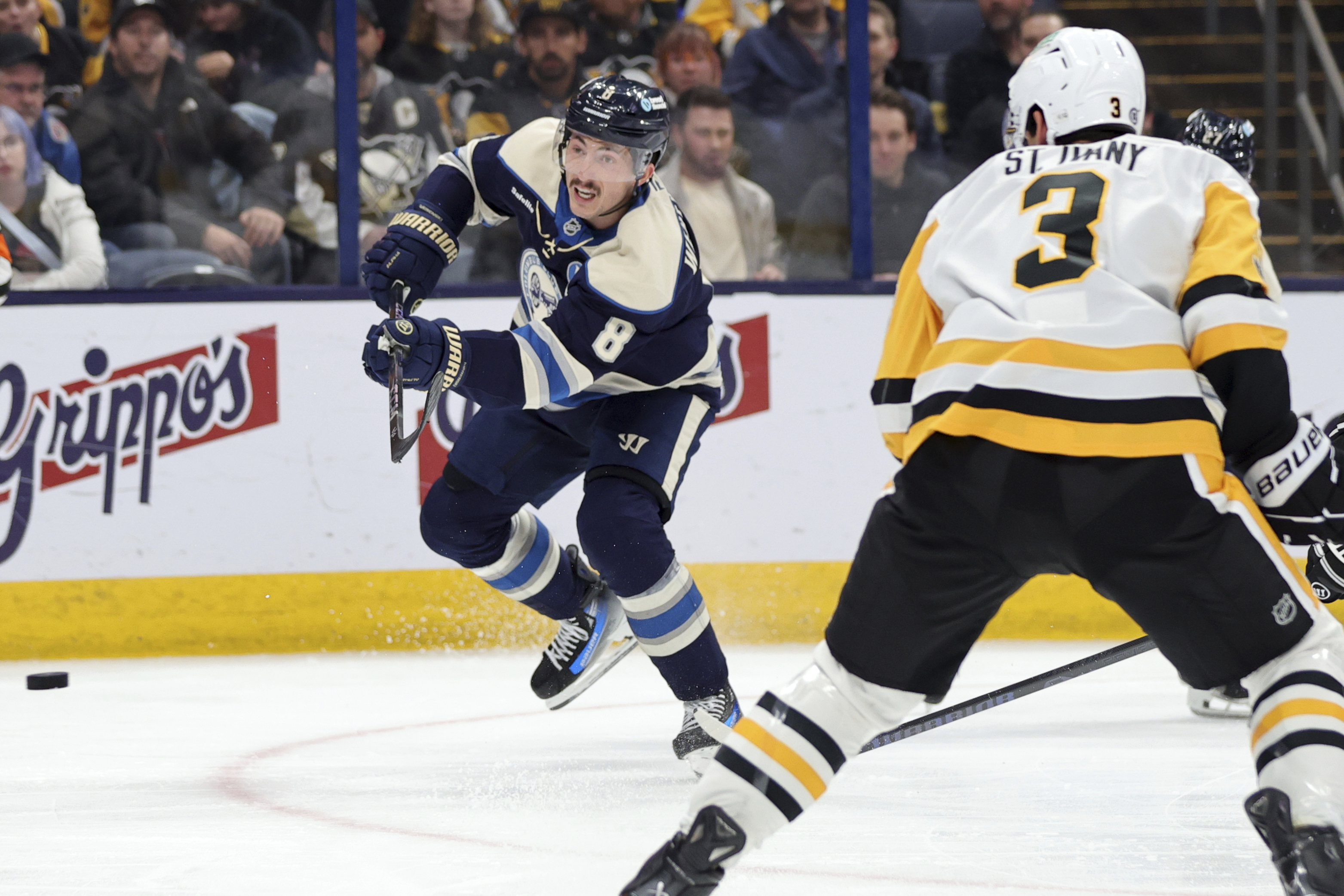 Columbus Blue Jackets defenseman Zach Werenski, left, shoots the puck in front of Pittsburgh Penguins defenseman Jack St. Ivany during the second period of an NHL hockey game in Columbus, Ohio, Friday, Nov. 15, 2024. 
