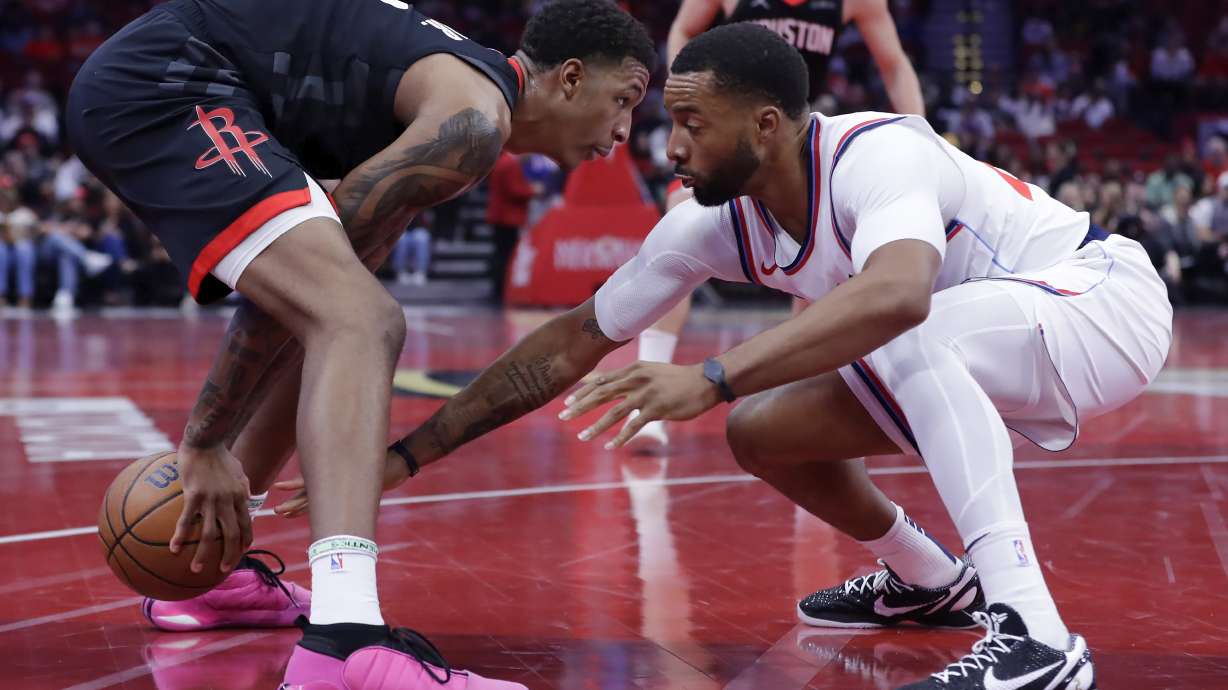 Houston Rockets forward Jabari Smith Jr., left, looks for a way around as Los Angeles Clippers guard Norman Powell, right, reaches in during the first half of an Emirates NBA Cup basketball game Friday, Nov. 15, 2024, in Houston.