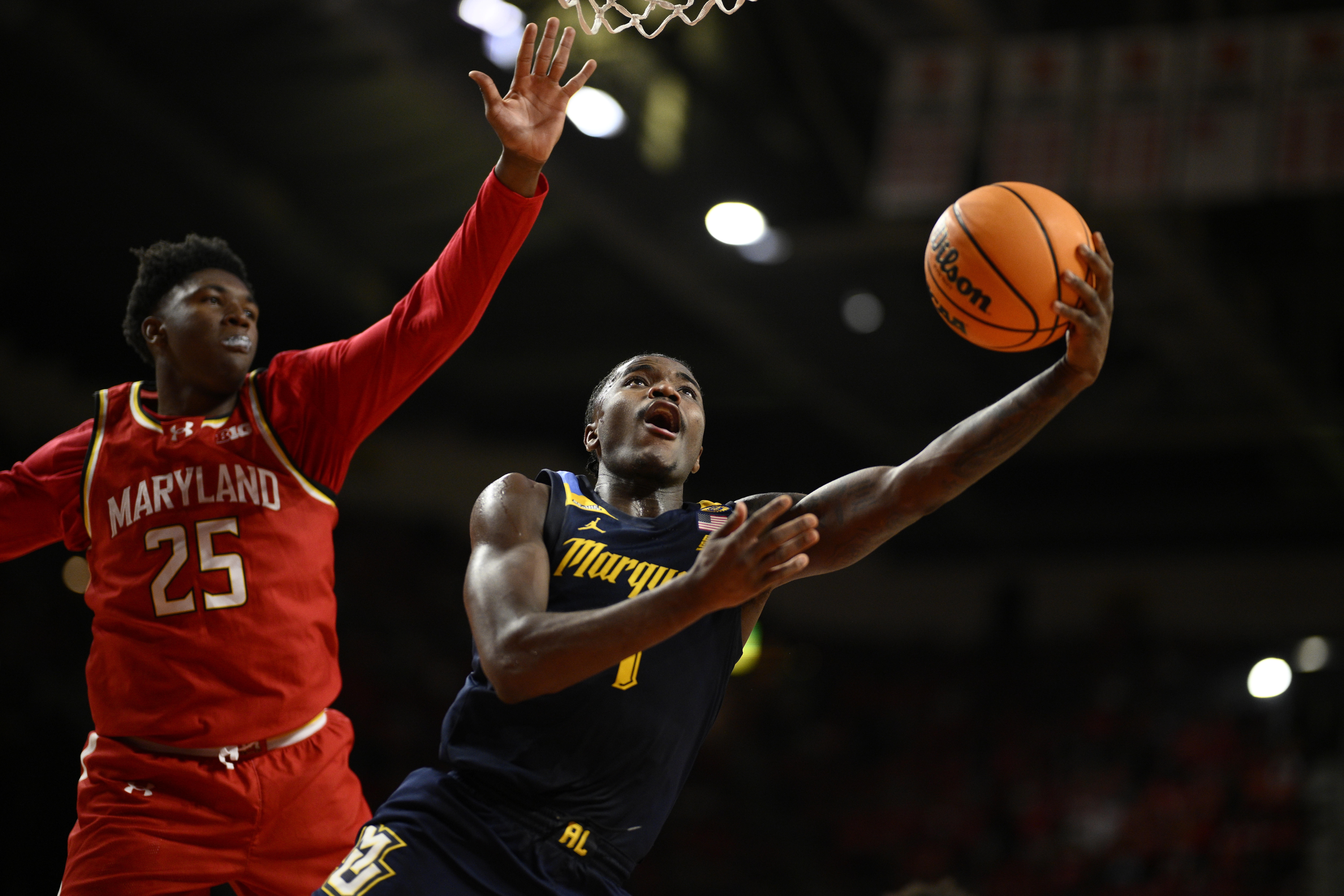 Marquette guard Kam Jones (1) goes to the basket past Maryland center Derik Queen (25) during the first half of an NCAA college basketball game, Friday, Nov. 15, 2024, in College Park, Md.