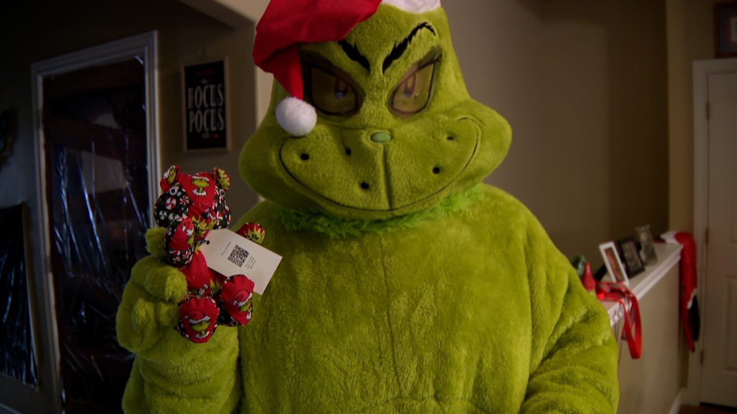 Kendall Reeve wears a Grinch costume while holding one of the bears that Gavin Reeve makes.