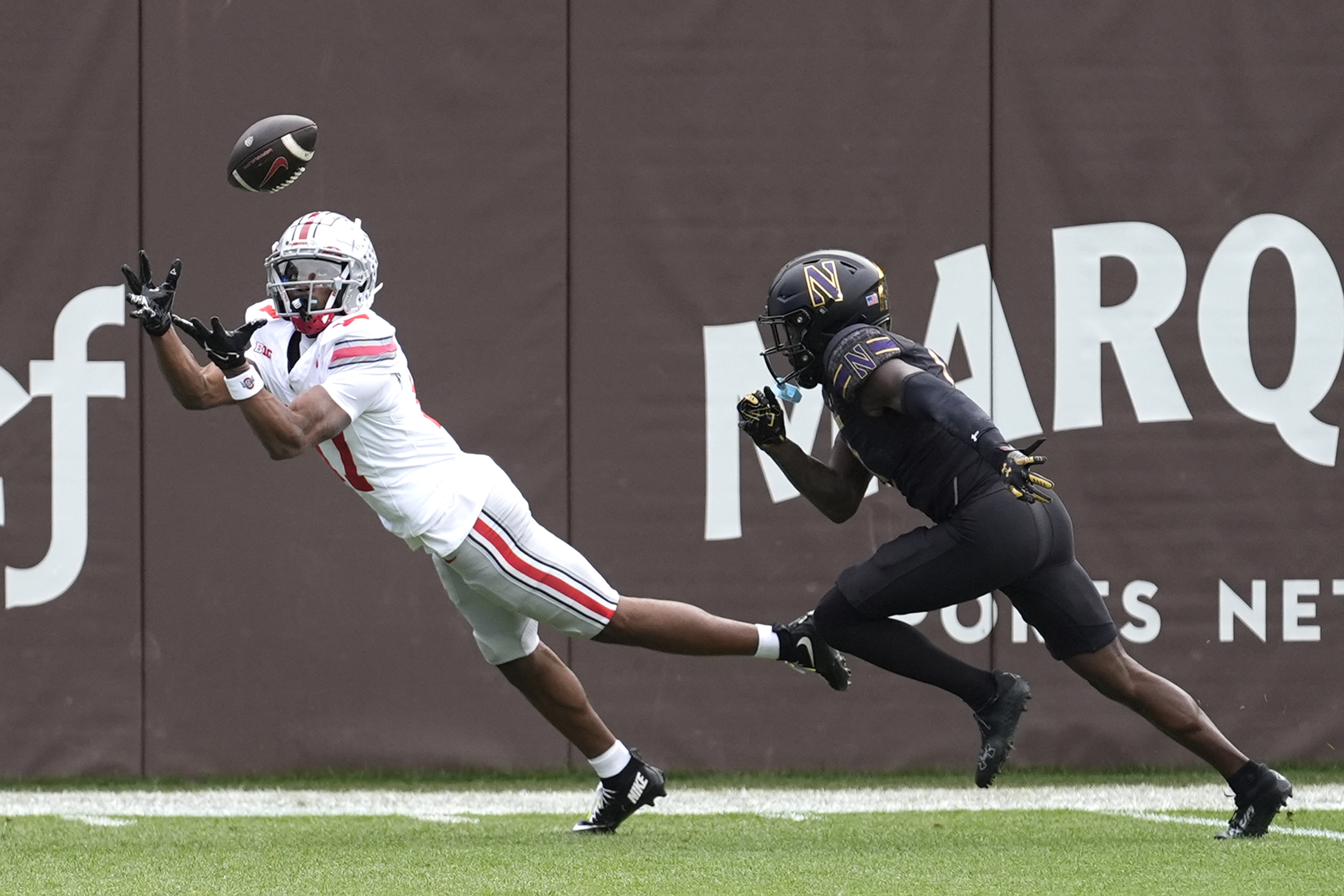 Ohio State wide receiver Carnell Tate State lays out for a touchdown pass as Northwestern defensive back Josh Fussell defends during the first half of an NCAA college football game at Wrigley Field on Saturday, Nov. 16, 2024, in Chicago.