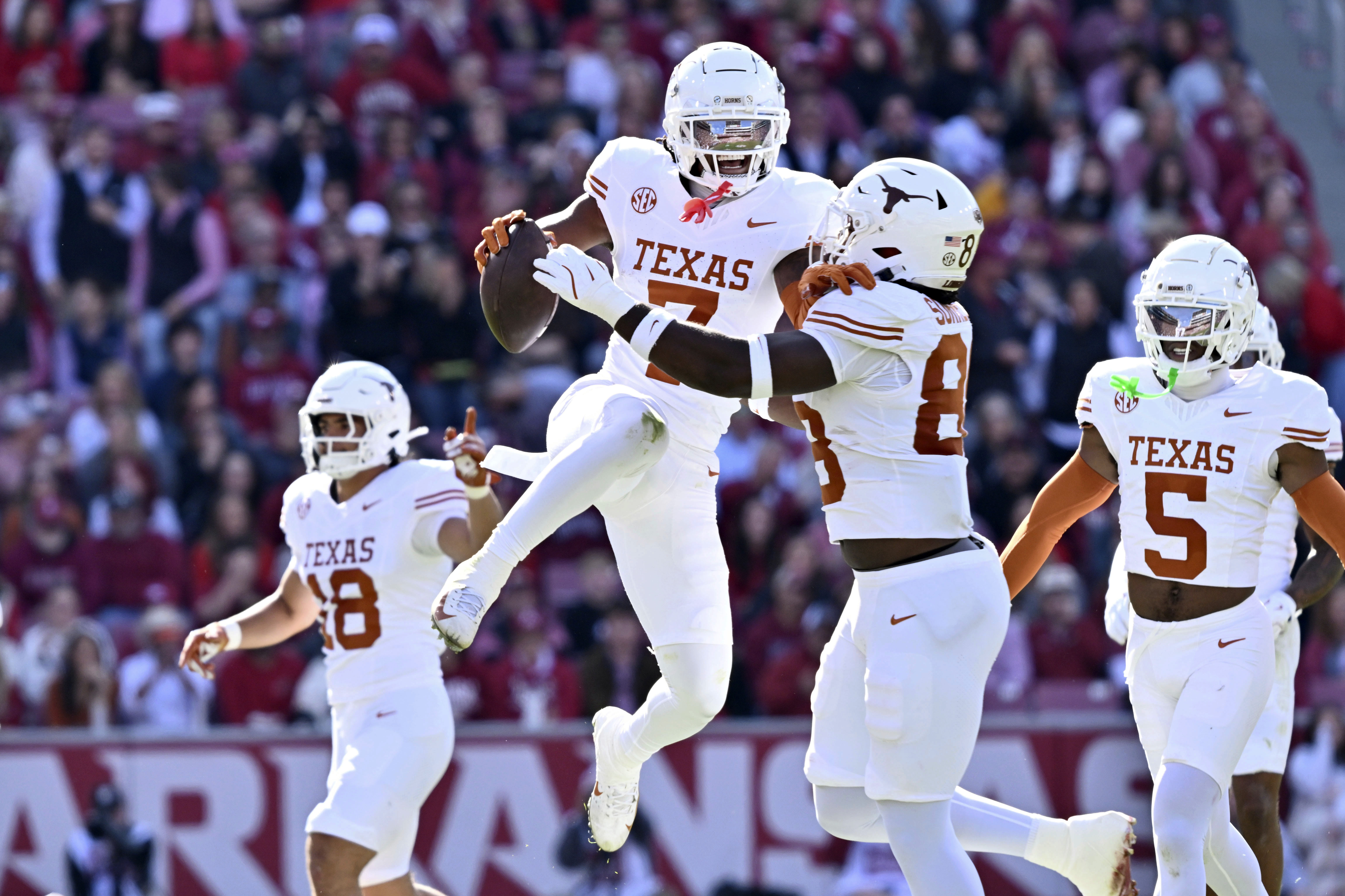Texas defensive back Jahdae Barron (7) celebrates with teammate Barryn Sorrell (88) after making in interception against Arkansas during the first half of an NCAA college football game Saturday, Nov. 16, 2024, in Fayetteville, Ark. 