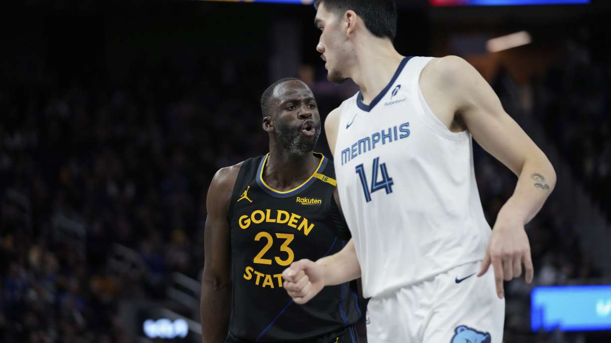 Golden State Warriors forward Draymond Green, left, reacts after making a 3-point basket during the second half of an Emirates NBA Cup basketball game against the Memphis Grizzlies, Friday, Nov. 15, 2024, in San Francisco.