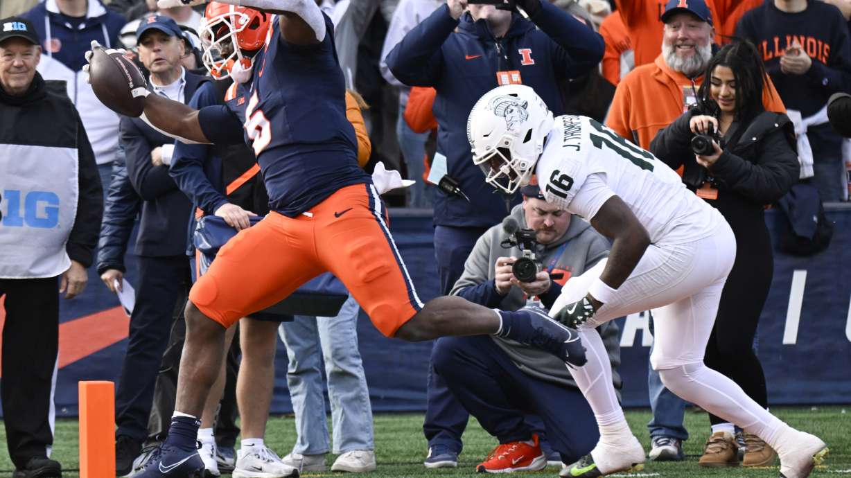 Illinois running back Ca'Lil Valentine (5) scores a touchdown ahead of Michigan State defensive back Jaylen Thompson (16) during the first half in an NCAA college football game, Saturday, Nov. 16, 2024, in Champaign, Ill.