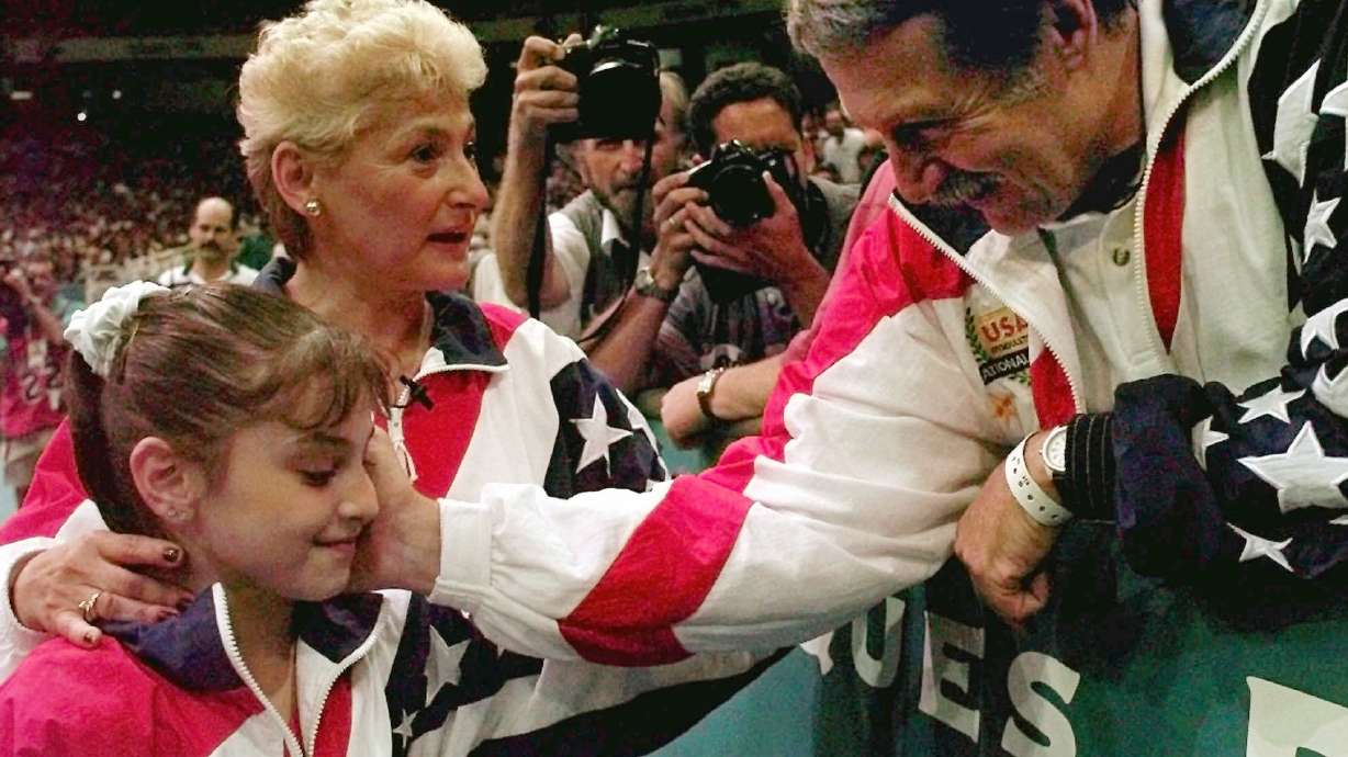 FILE - Bela Karolyi, right, congratulates Dominique Moceanu, left, after the United States captured the gold medal in the women's team gymnastics competition at the Centennial Summer Olympic Games in Atlanta, July 23, 1996.