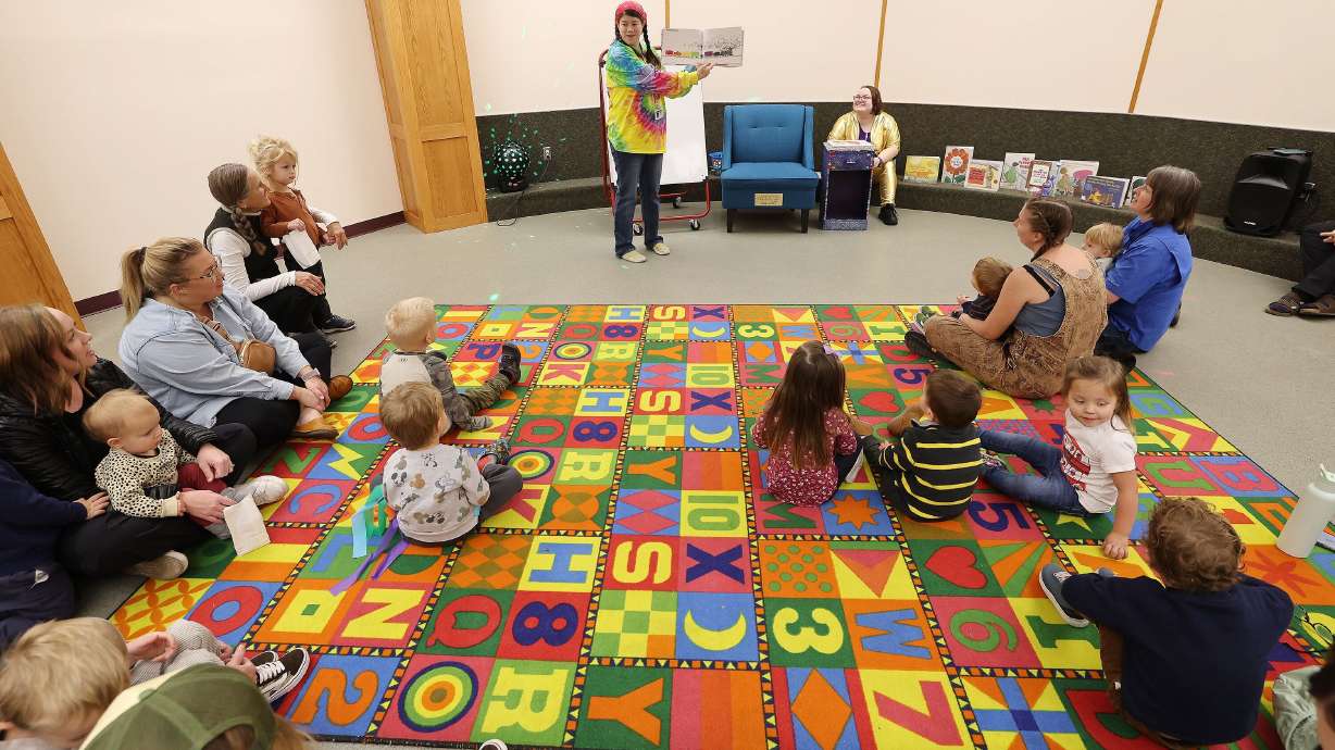 Librarian Betsy Flake reads to children during the Whitmore Library 50th year celebration in Cottonwood Heights on Friday.
