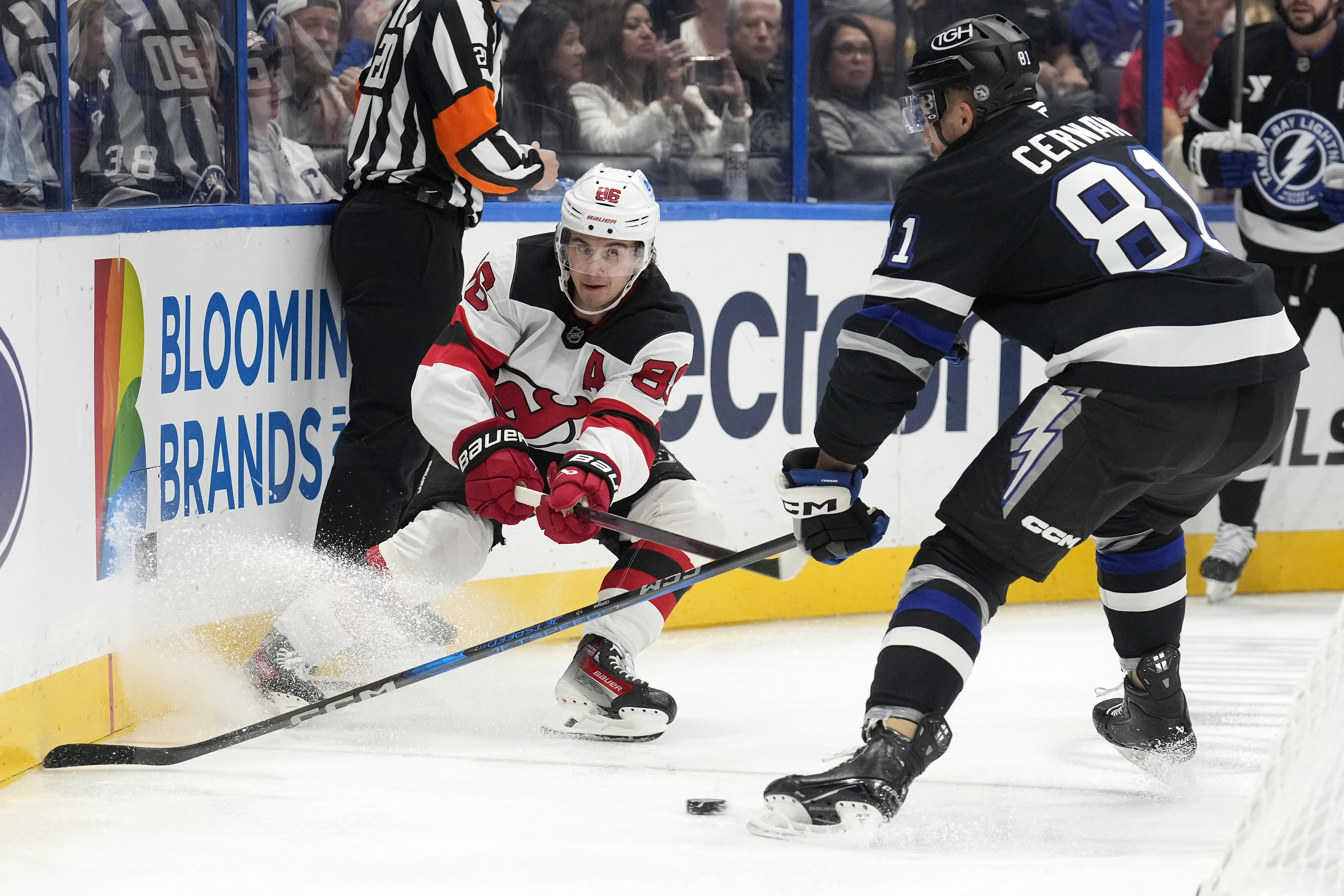 New Jersey Devils center Jack Hughes (86) slips the puck away from Tampa Bay Lightning defenseman Erik Cernak (81) during the first period of an NHL hockey game Saturday, Nov. 16, 2024, in Tampa, Fla. 