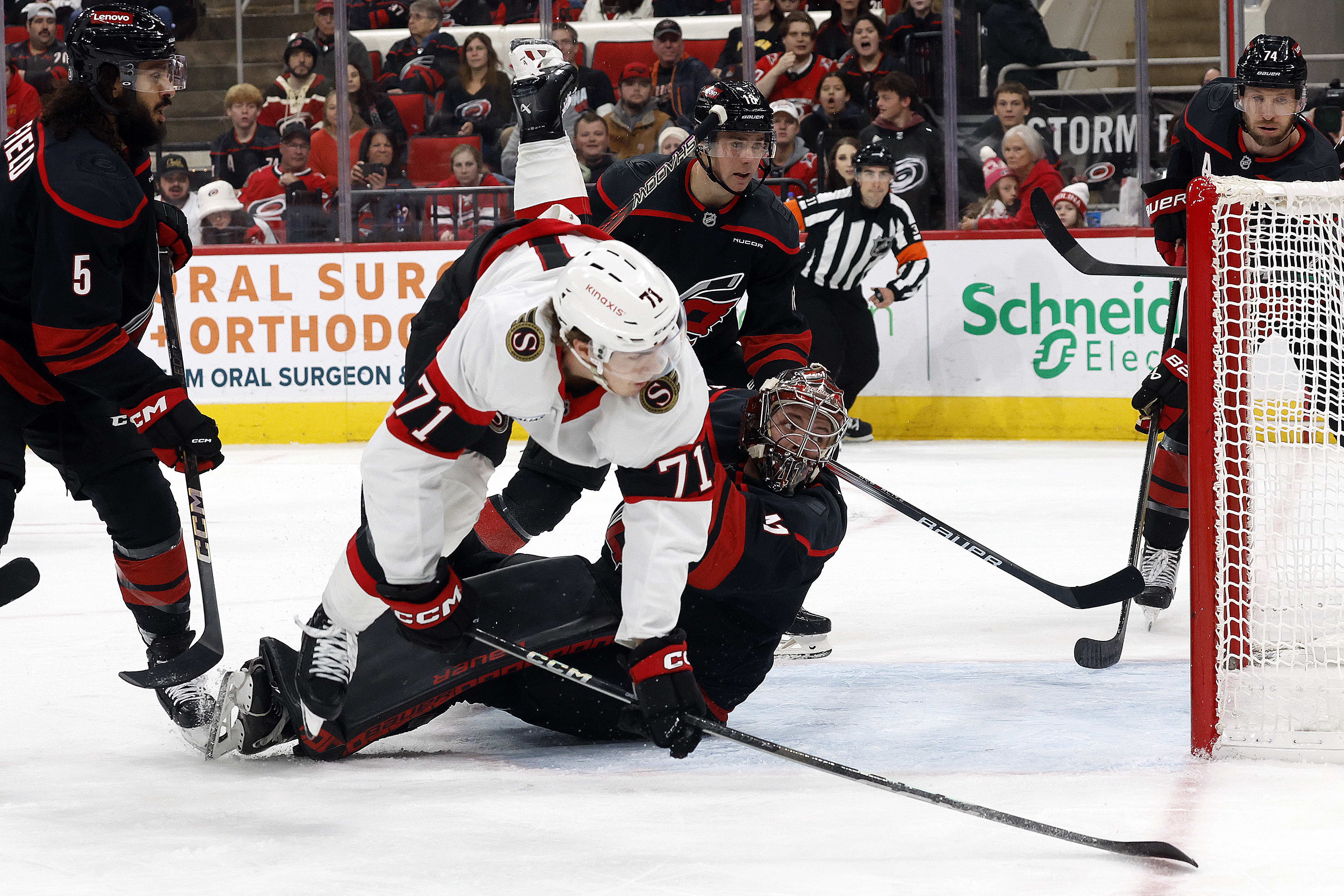 Ottawa Senators' Ridly Greig (71) collides with Carolina Hurricanes goaltender Spencer Martin (41) during the first period of an NHL hockey game in Raleigh, N.C., Saturday, Nov. 16, 2024. 