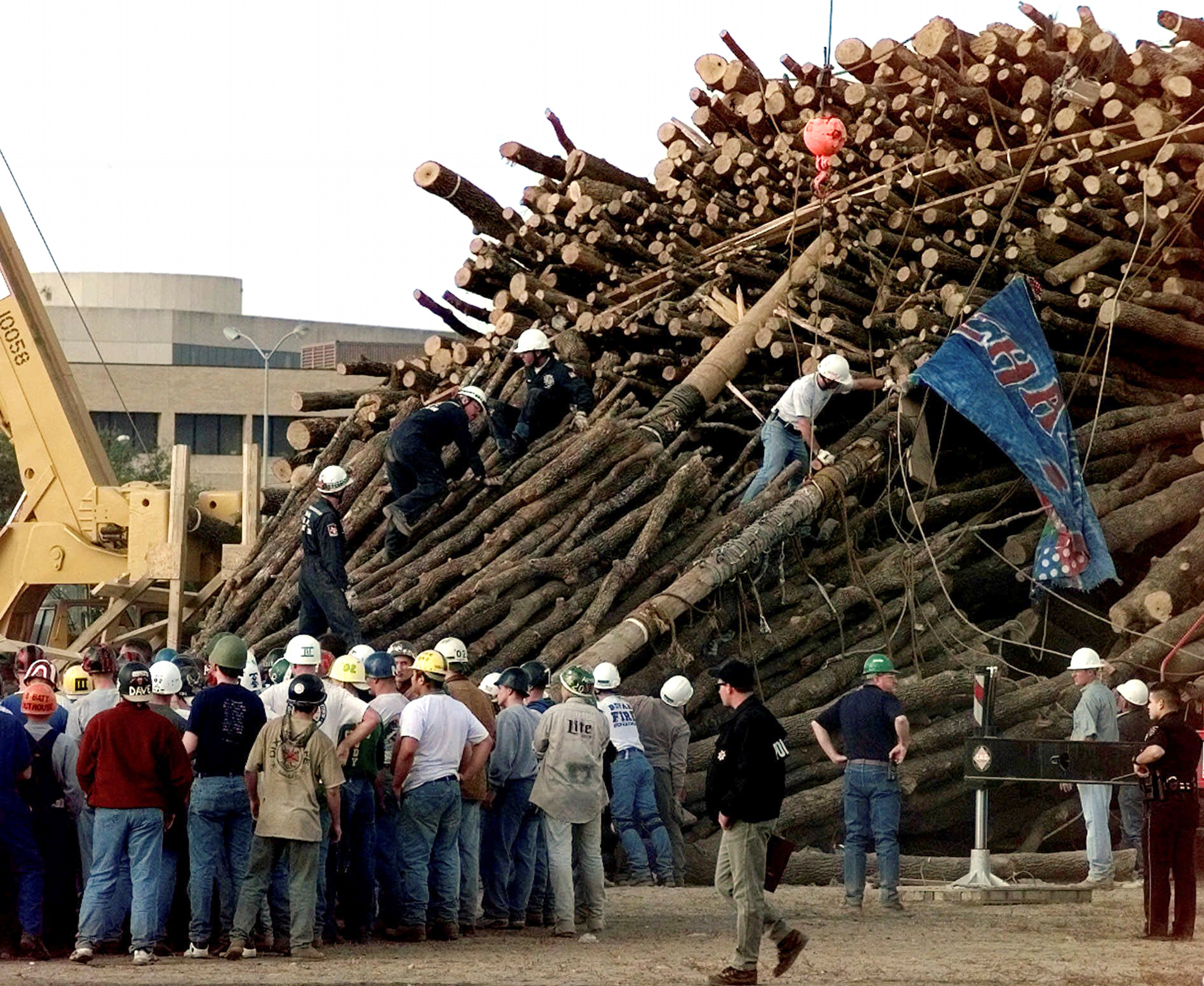 FILE - Texas A&M students and rescue workers gathered at the base of the collapsed bonfire stack as the search continues for victims in College Station, Texas, Nov. 18, 1999. 