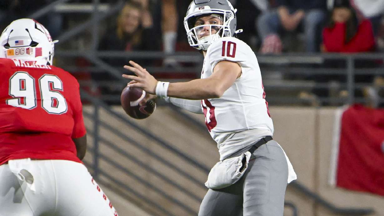 Washington State's quarterback John Mateer (10) looks to pass as he avoids the rush from New Mexico's Garrison Walker (96) during an NCAA college football game Saturday Nov. 16, 2024, in Albuquerque, N.M.