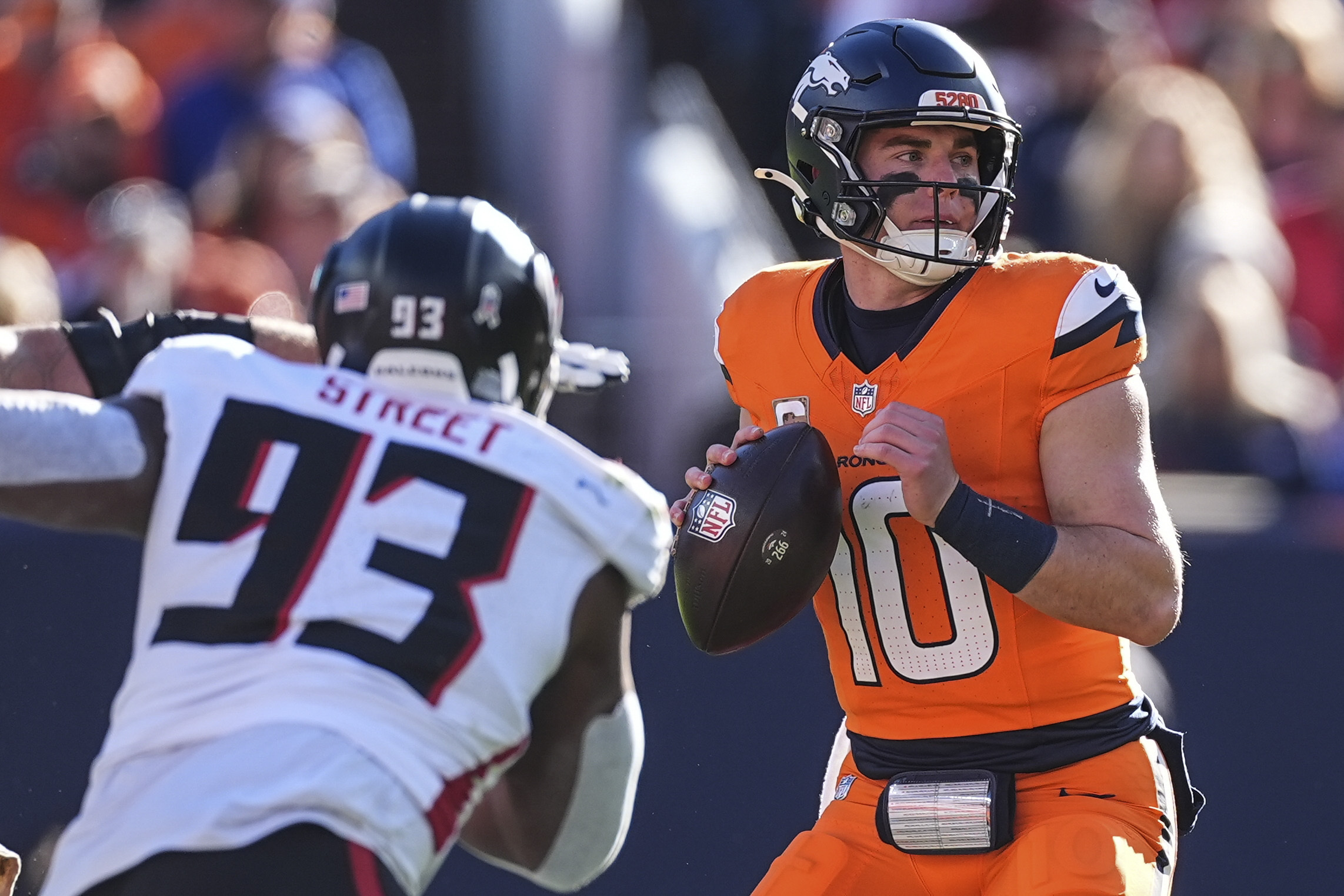 Denver Broncos quarterback Bo Nix (10) works in the pocket as Atlanta Falcons defensive tackle Kentavius Street (93) pressures during the first half of an NFL football game, Sunday, Nov. 17, 2024, in Denver. 