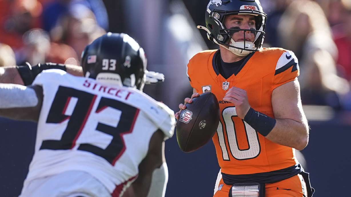 Denver Broncos quarterback Bo Nix (10) works in the pocket as Atlanta Falcons defensive tackle Kentavius Street (93) pressures during the first half of an NFL football game, Sunday, Nov. 17, 2024, in Denver.