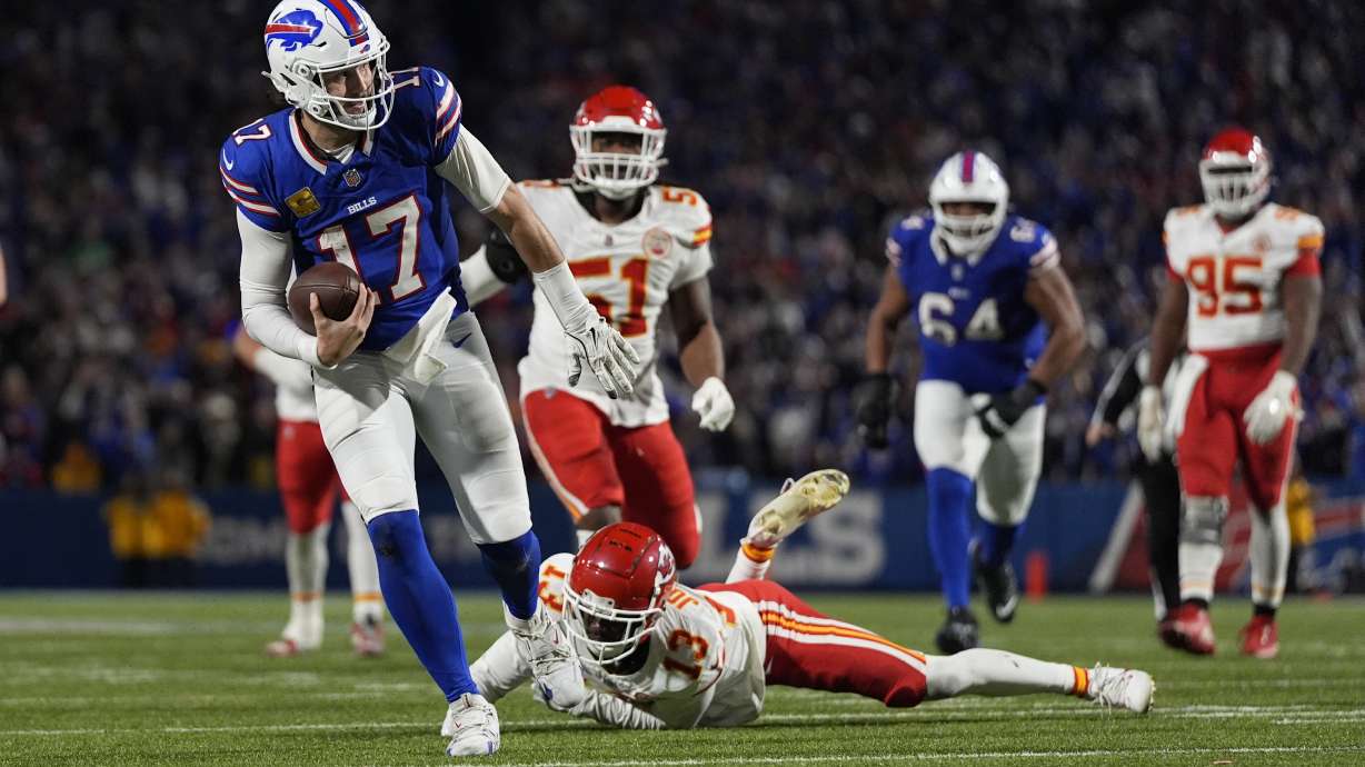 Buffalo Bills quarterback Josh Allen (17) slips past Kansas City Chiefs cornerback Nazeeh Johnson (13) to score on a 26-yard run during the second half of an NFL football game Sunday, Nov. 17, 2024, in Orchard Park, N.Y.