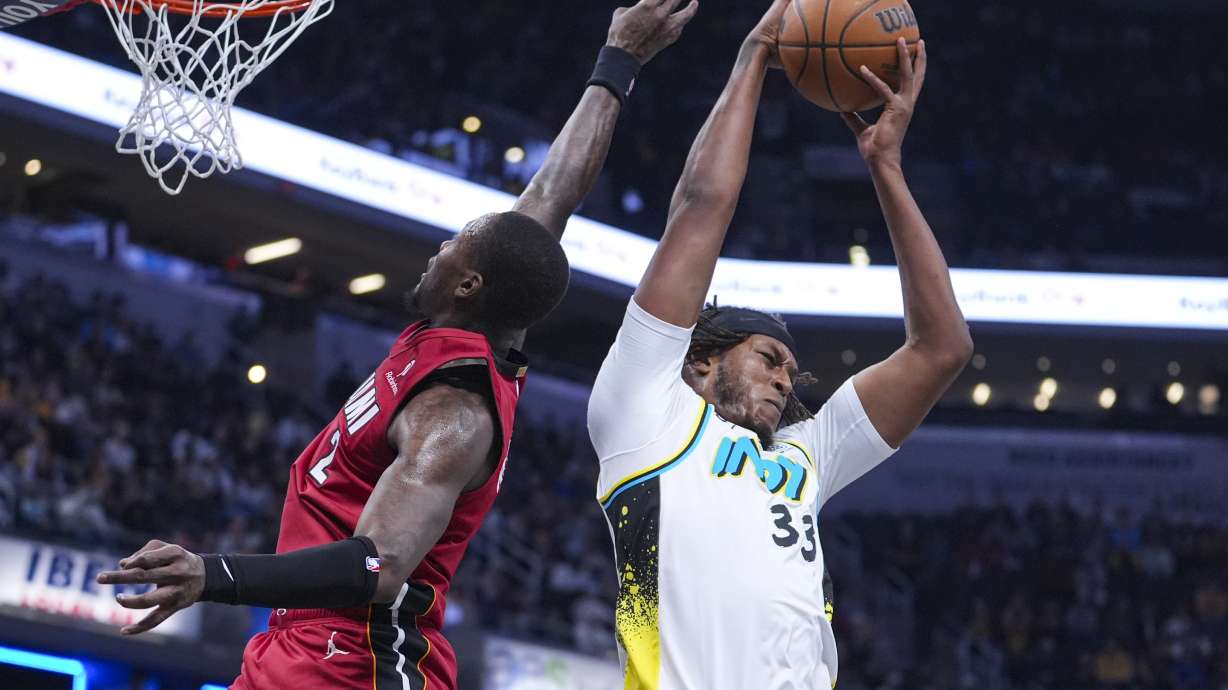 Indiana Pacers center Myles Turner (33) grabs a rebound behind Miami Heat guard Terry Rozier (2) during the first half of an NBA basketball game in Indianapolis, Sunday, Nov. 17, 2024.