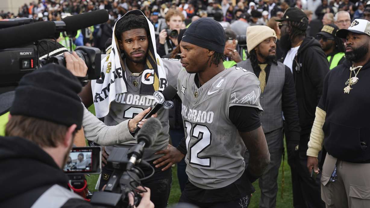 Colorado wide receiver Travis Hunter, right, answers a question as quarterback Shedeur Sanders looks on as the pair are interviewed following an NCAA college football game against Utah, Saturday, Nov. 16, 2024, in Boulder, Colo.