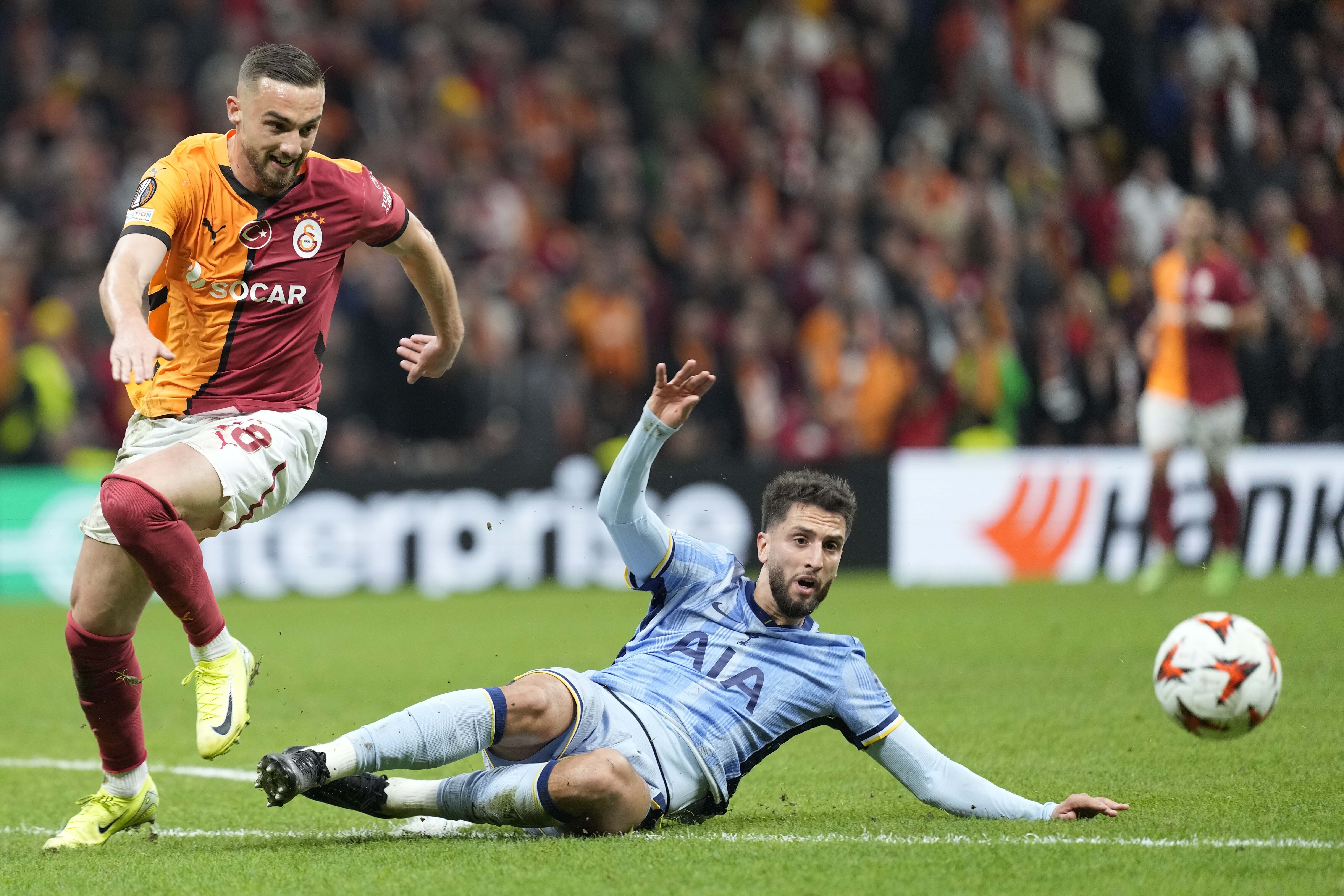 Galatasaray's Berkan Kutlu challenges for the ball Tottenham's Rodrigo Bentancur during the Europa League opening phase soccer match between Galatasaray and Tottenham Hotspur at Ali Sami Yen stadium, in Istanbul, Turkey, Thursday, Nov. 7, 2024. 