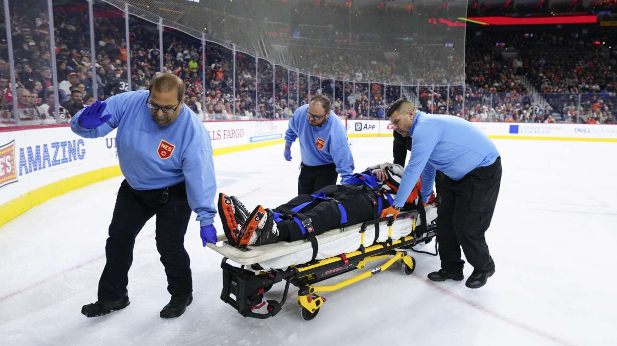 Referee Mitch Dunning, center, is stretchered off the ice after an injury during the first period of an NHL hockey game between the Philadelphia Flyers and the Colorado Avalanche, Monday, Nov. 18, 2024, in Philadelphia.