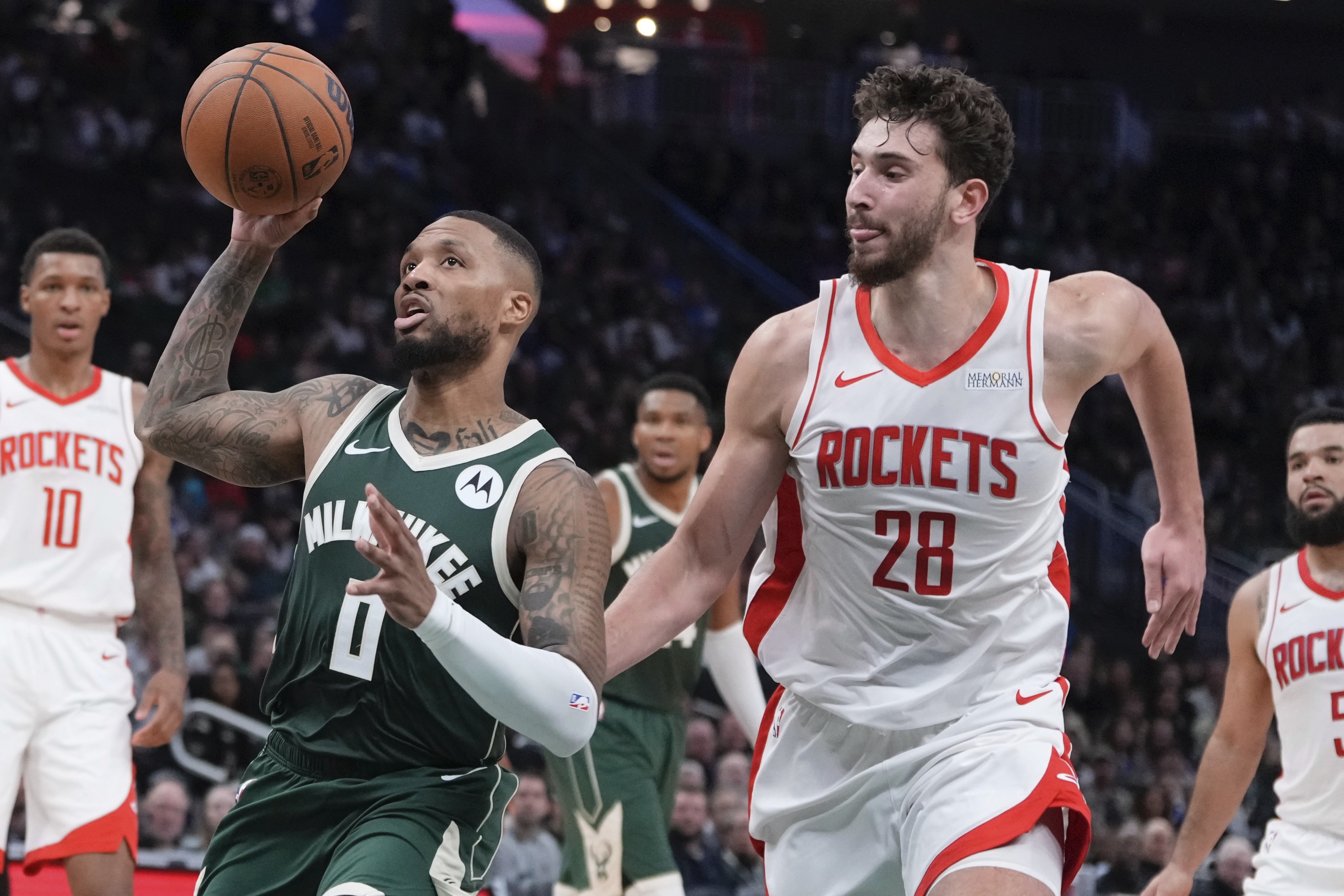 Milwaukee Bucks' Damian Lillard drives past Houston Rockets' Alperen Sengun during the first half of an NBA basketball game Monday, Nov. 18, 2024, in Milwaukee.