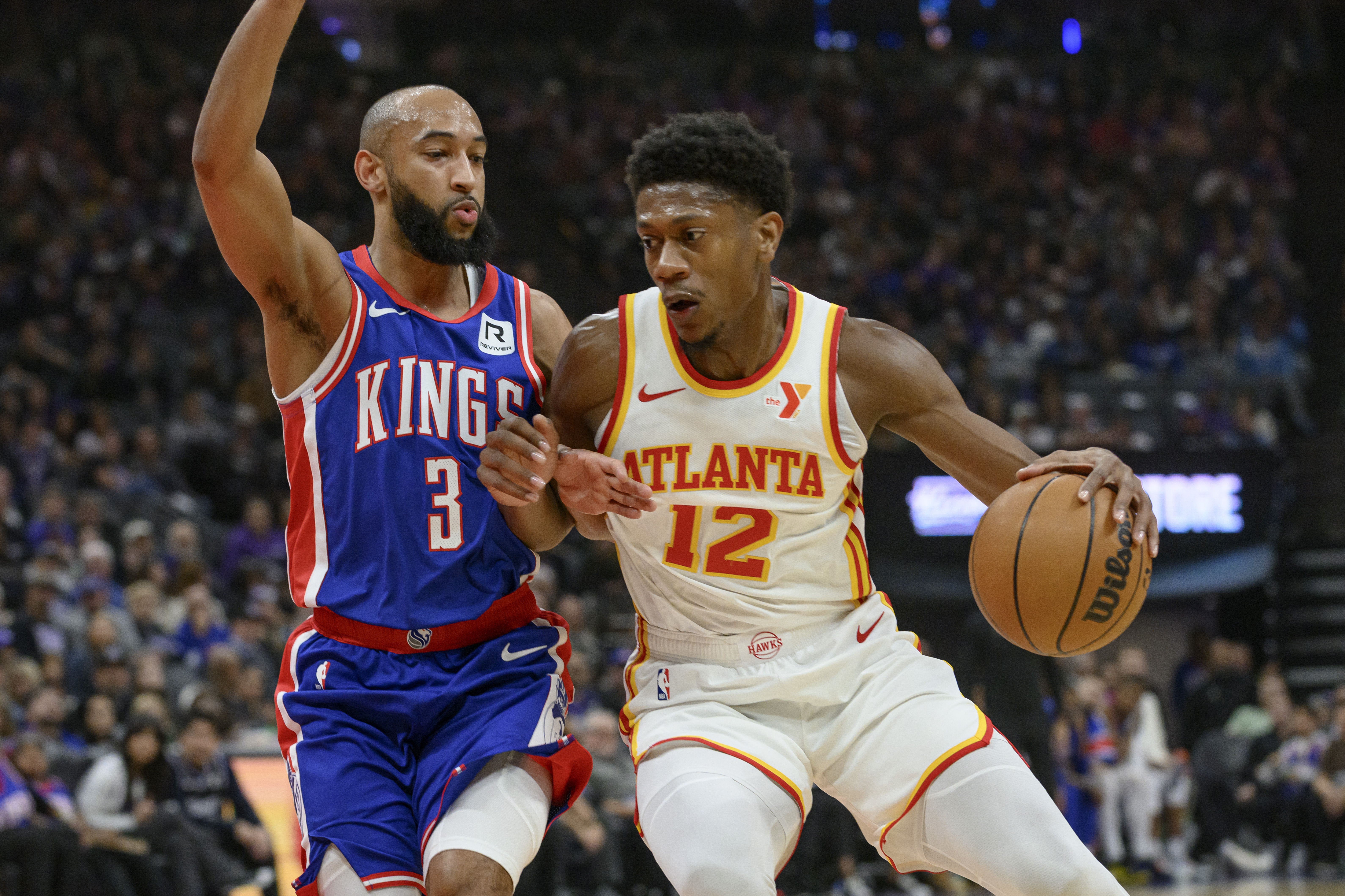 Atlanta Hawks forward De'Andre Hunter (12) is guarded by Sacramento Kings guard Jordan McLaughlin (3) during the first half of an NBA basketball game in Sacramento, Calif., Monday, Nov. 18, 2024. 